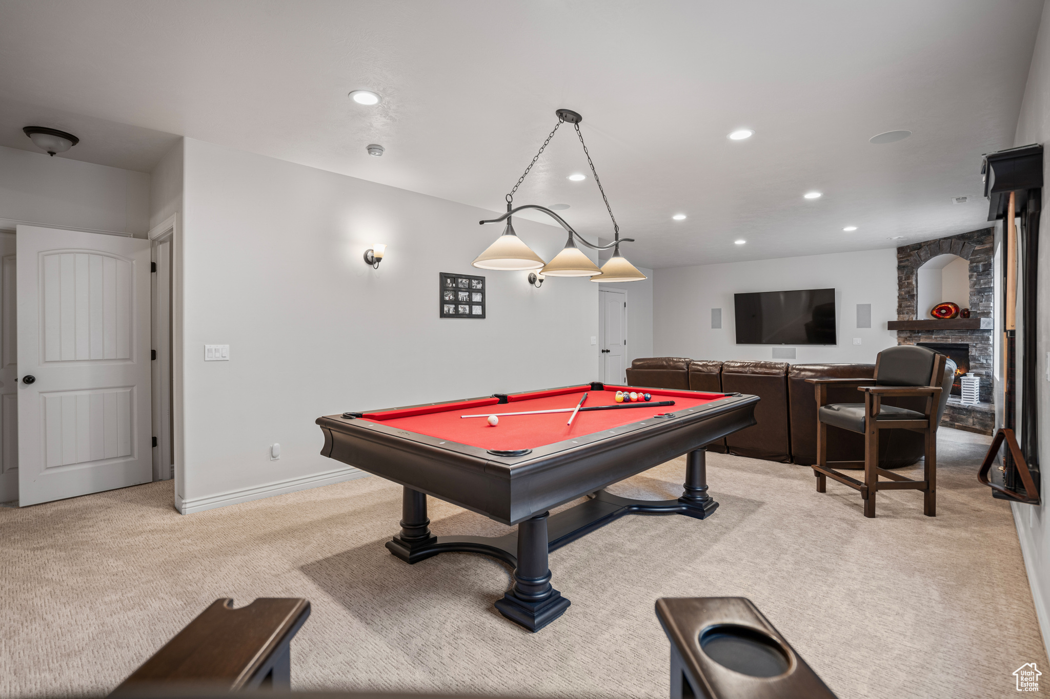 Game room featuring light carpet, pool table, and a fireplace