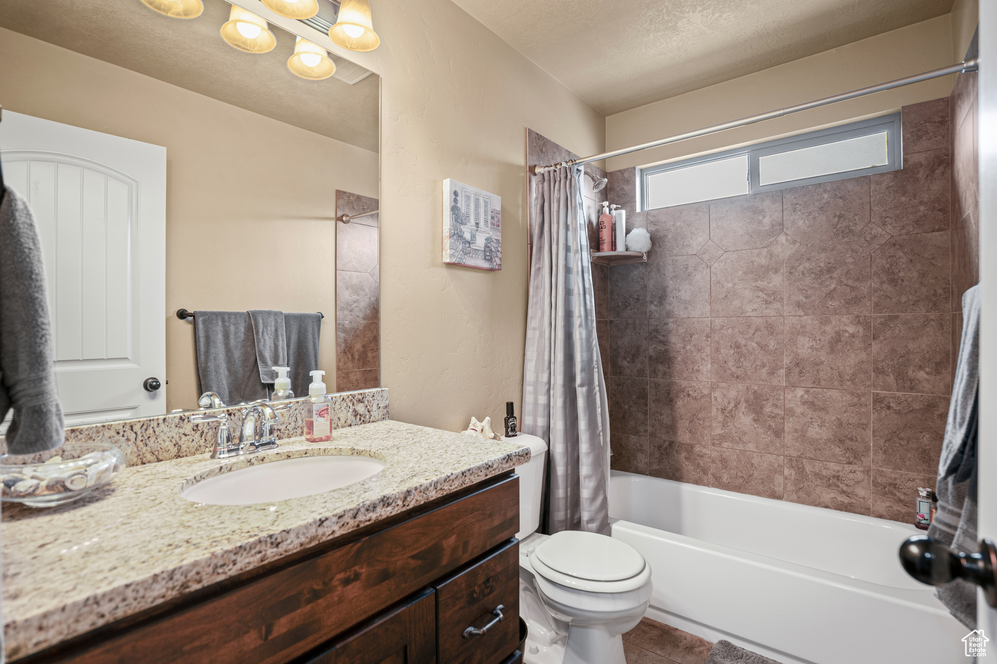 Full bathroom featuring shower / tub combo, toilet, tile flooring, and vanity