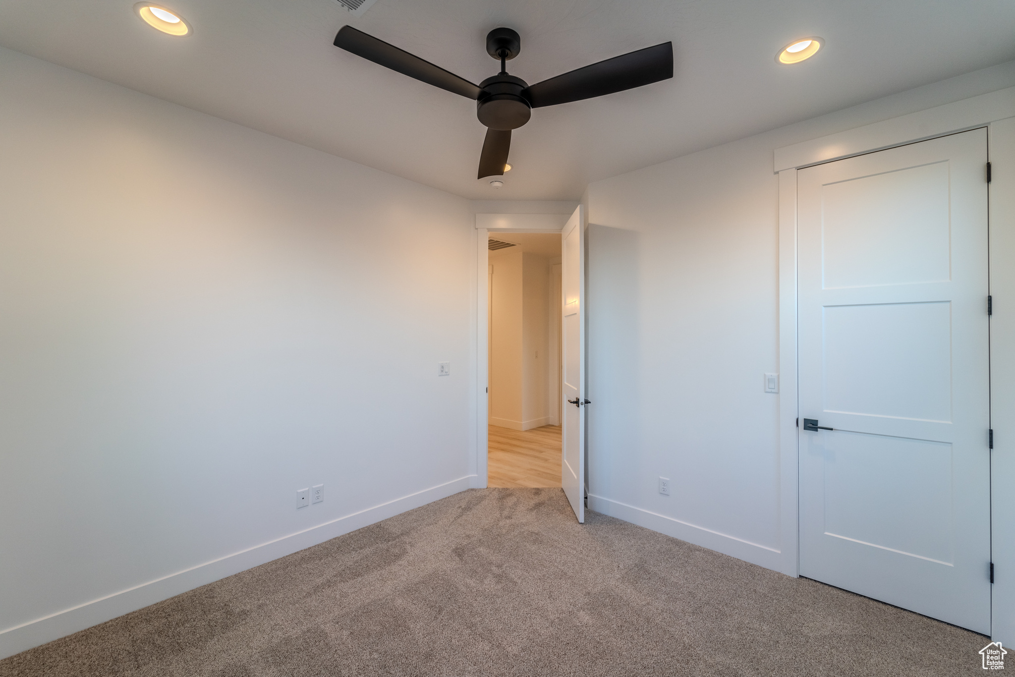 Unfurnished bedroom featuring ceiling fan and light carpet