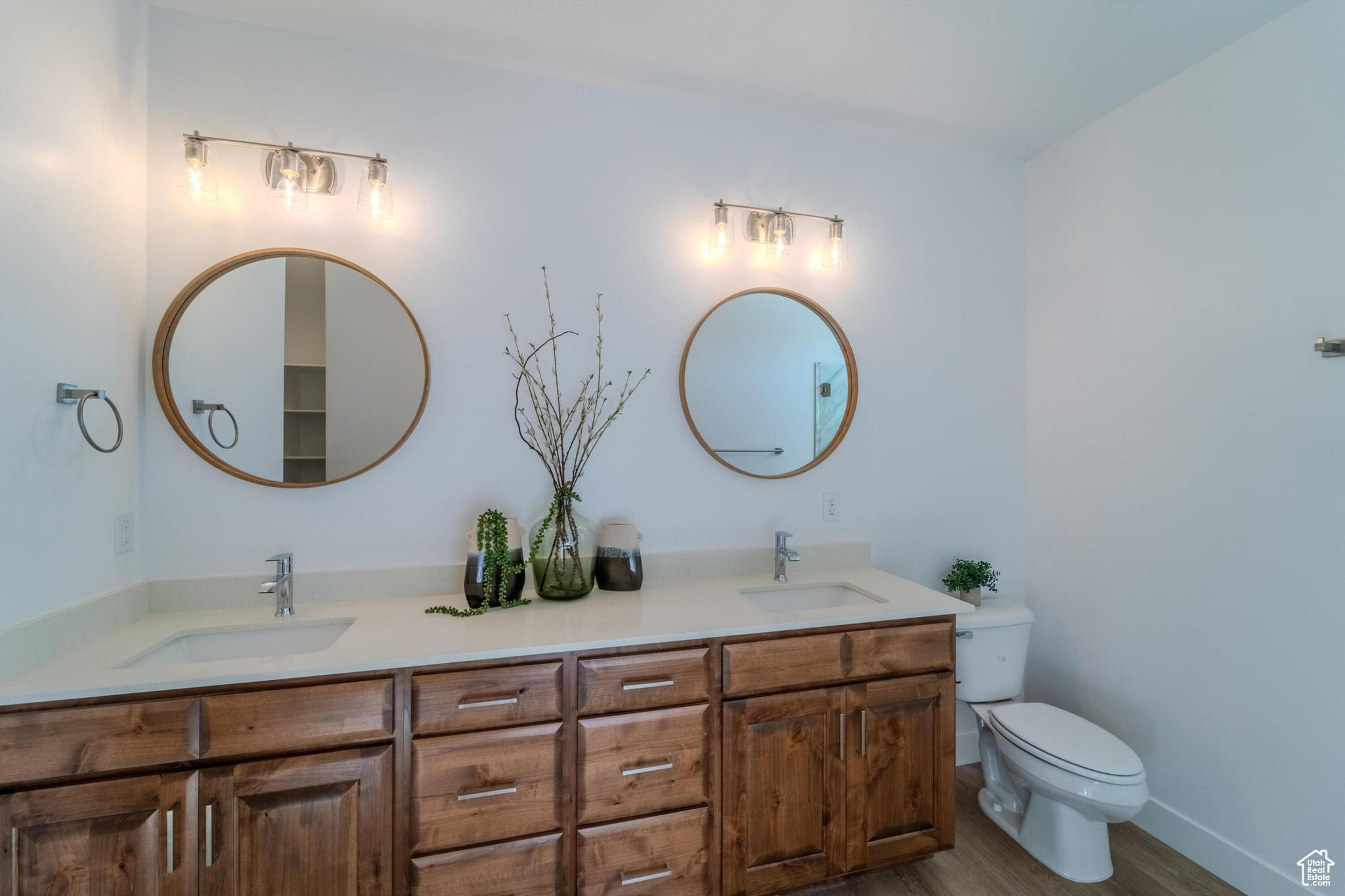 Bathroom with toilet, wood-type flooring, and double vanity