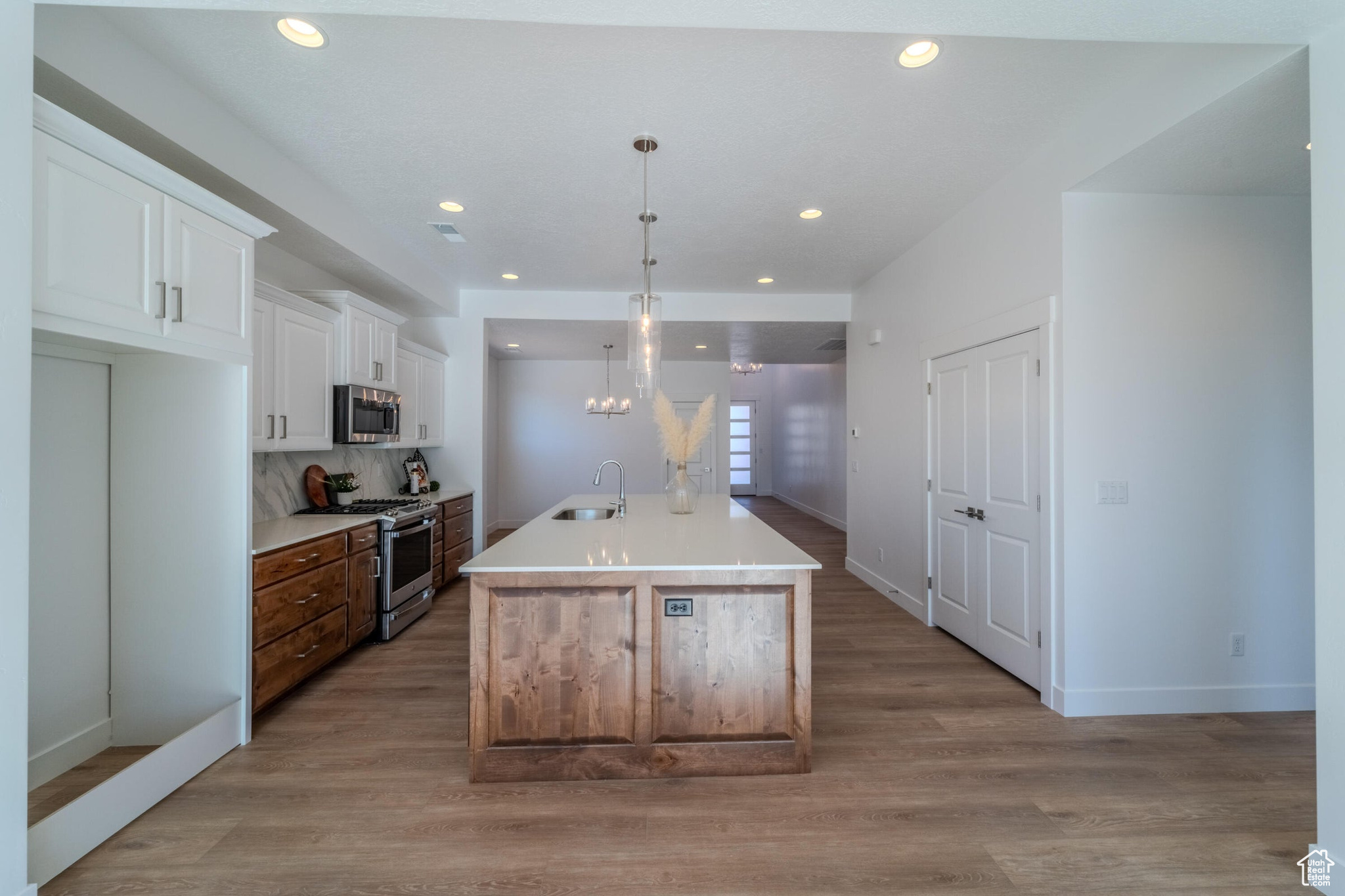 Kitchen featuring sink, white cabinetry, light hardwood / wood-style flooring, and stainless steel appliances