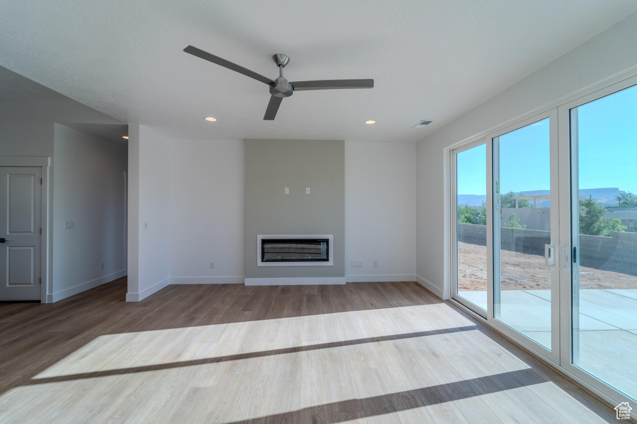 Unfurnished living room featuring hardwood / wood-style flooring and ceiling fan