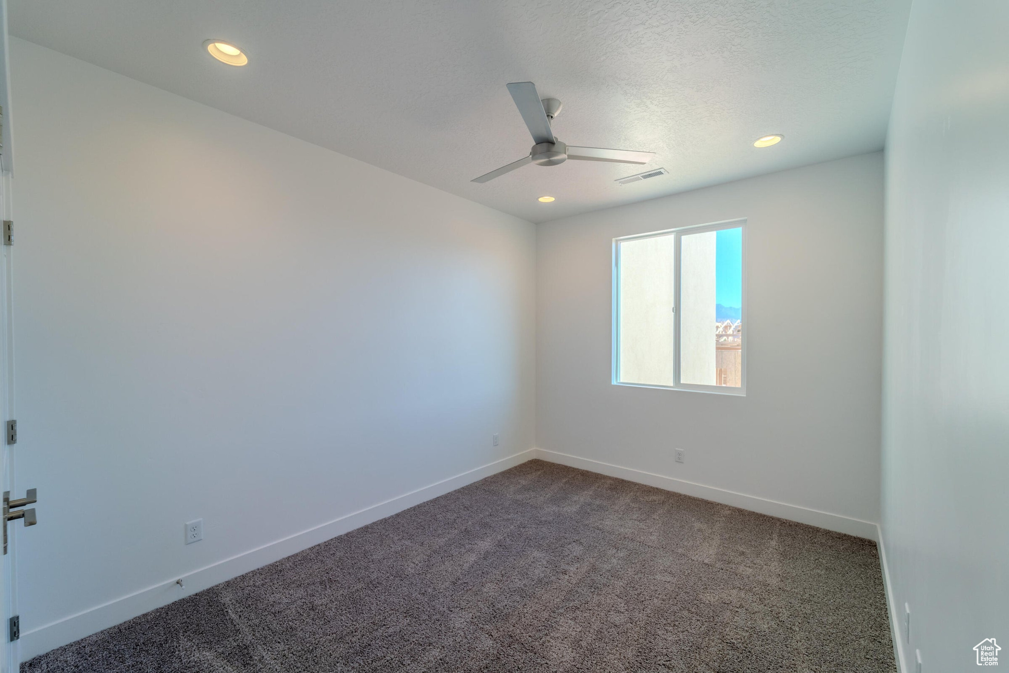 Unfurnished room featuring carpet flooring and ceiling fan