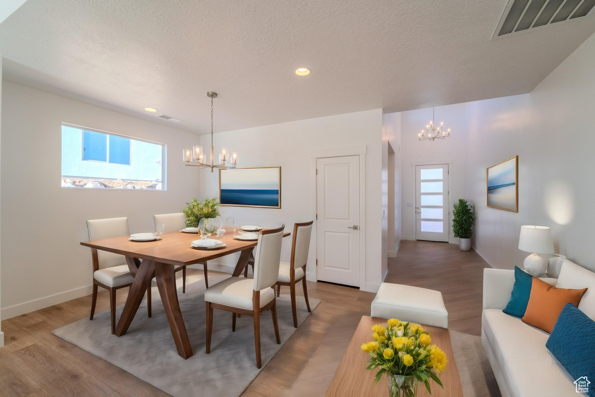 Dining space featuring hardwood / wood-style flooring, a healthy amount of sunlight, and an inviting chandelier