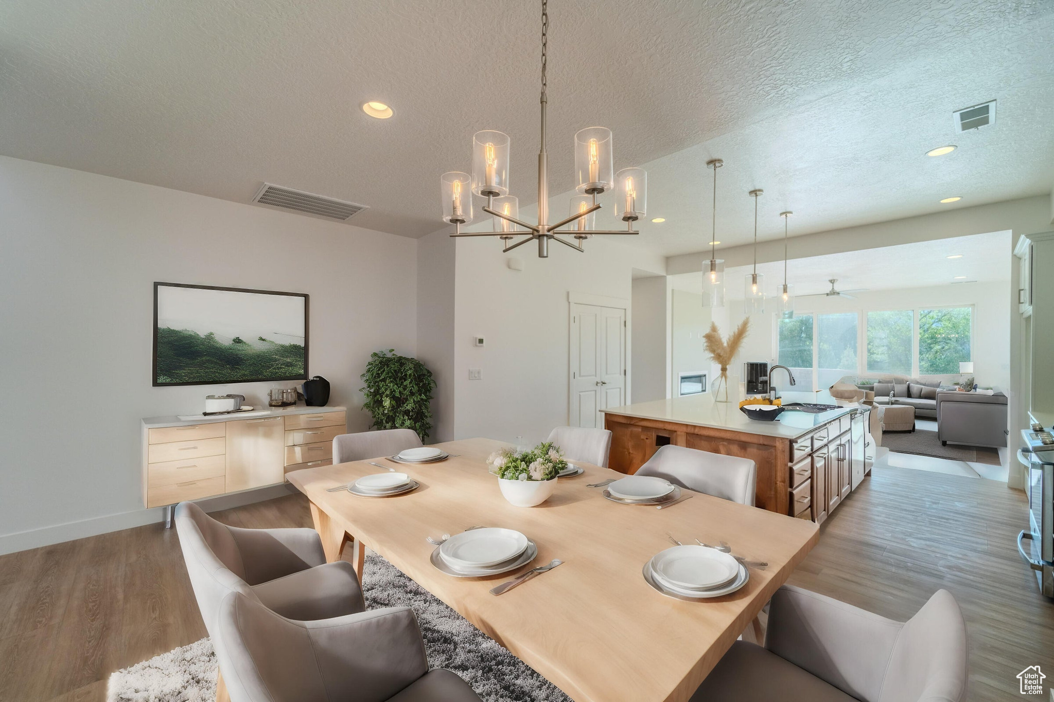 Dining space featuring hardwood / wood-style flooring, sink, a chandelier, and a textured ceiling