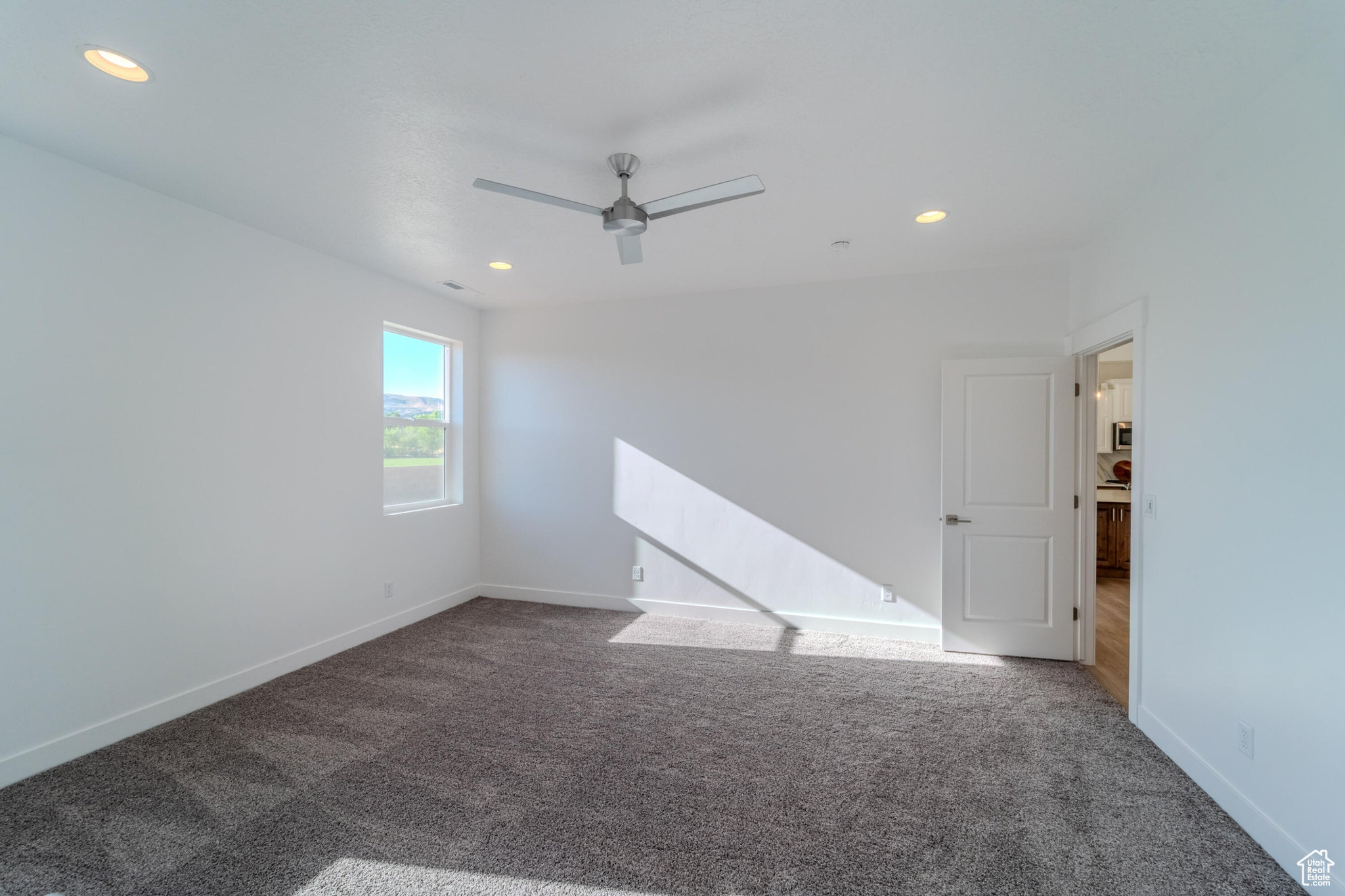 Empty room featuring carpet floors and ceiling fan