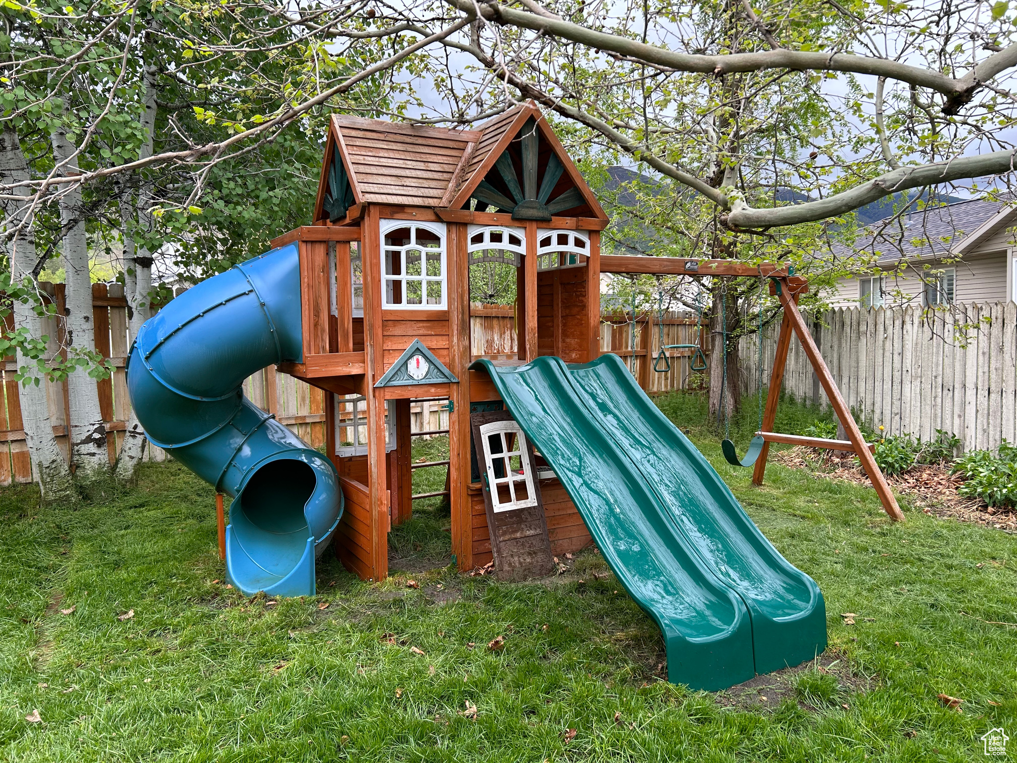 View of Backyard with a swing set with slides. *INCLUDED*