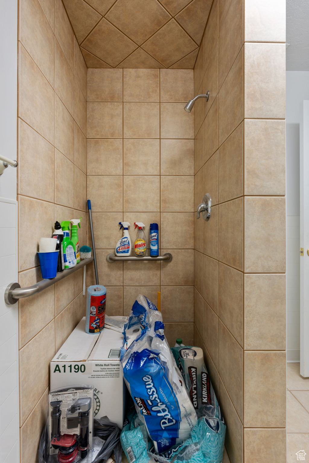 Bathroom with tiled shower and tile walls