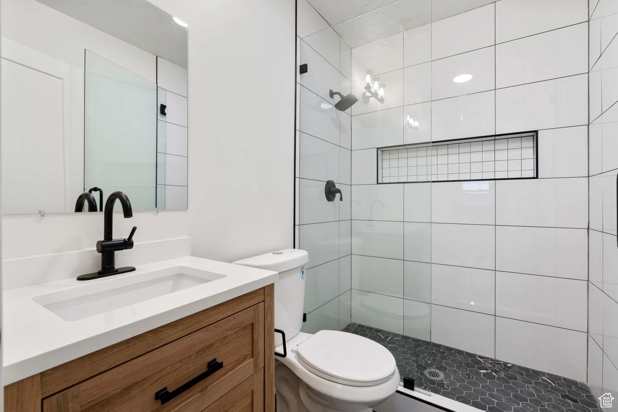 Bathroom with oversized vanity, an enclosed shower, and toilet