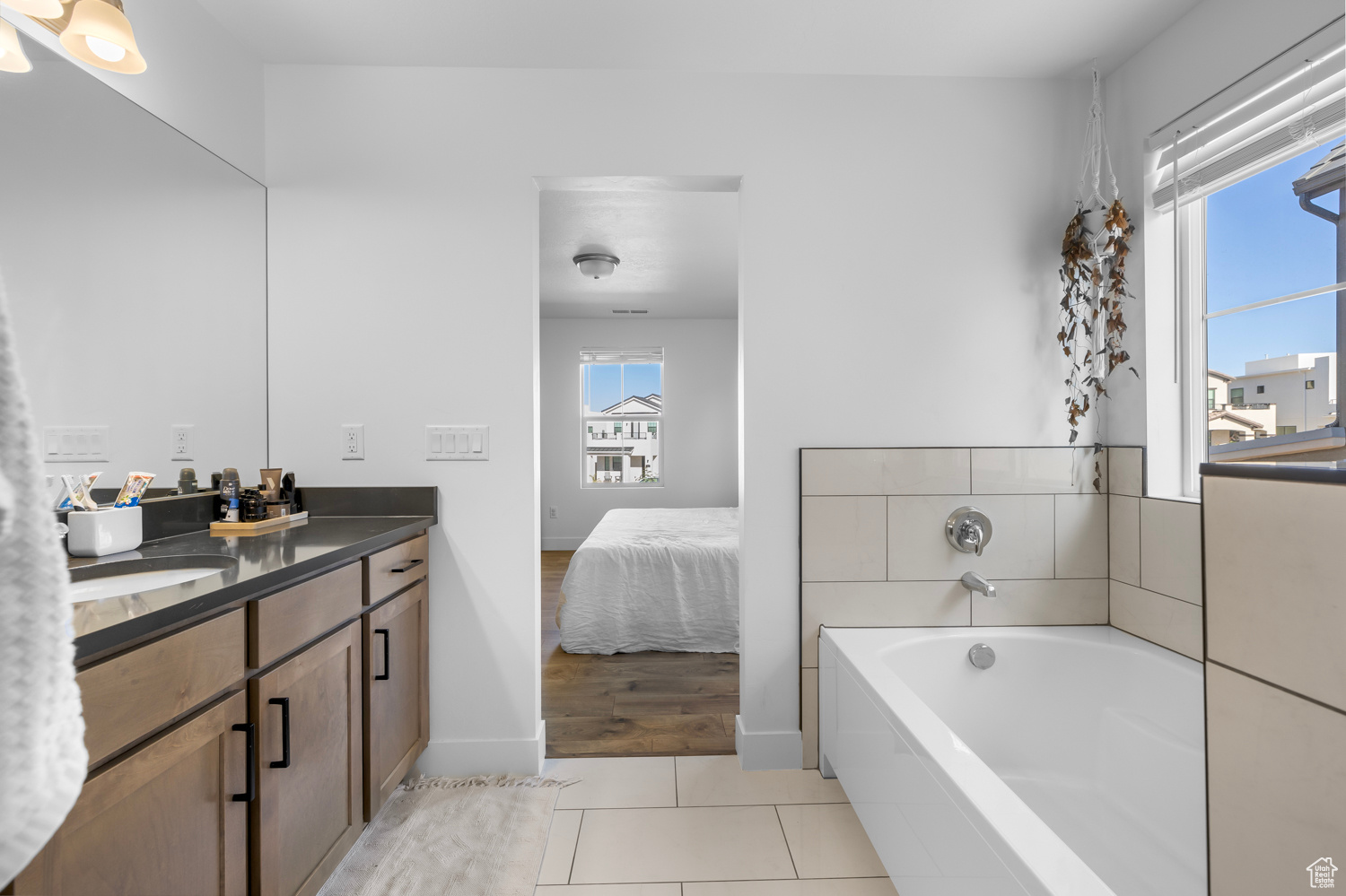 Bathroom featuring tile flooring, a bathing tub, and dual vanity