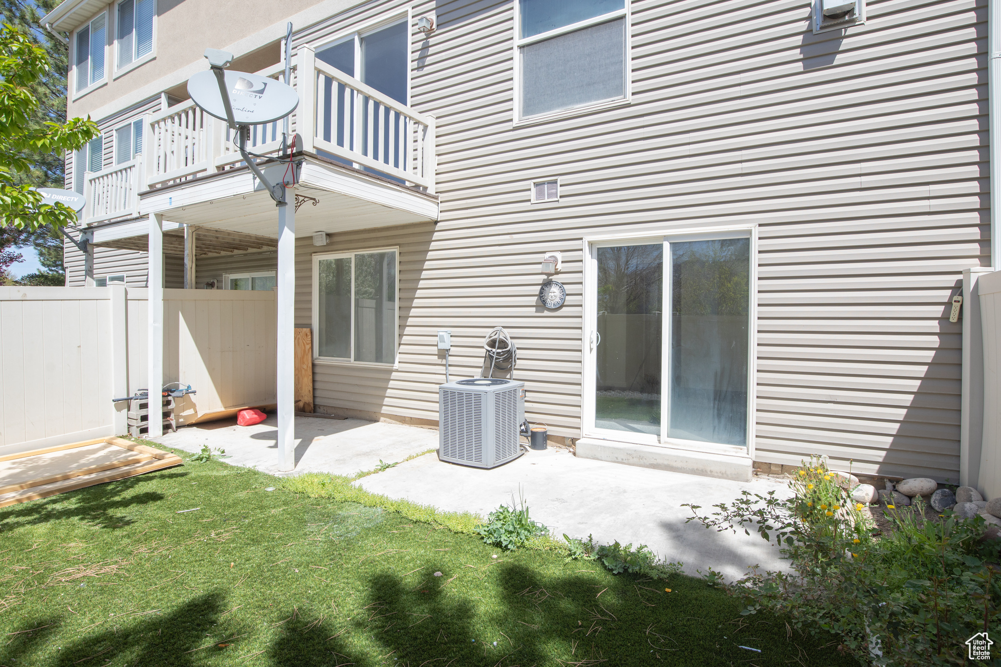Rear view of property featuring central AC, a yard, a balcony, and a patio