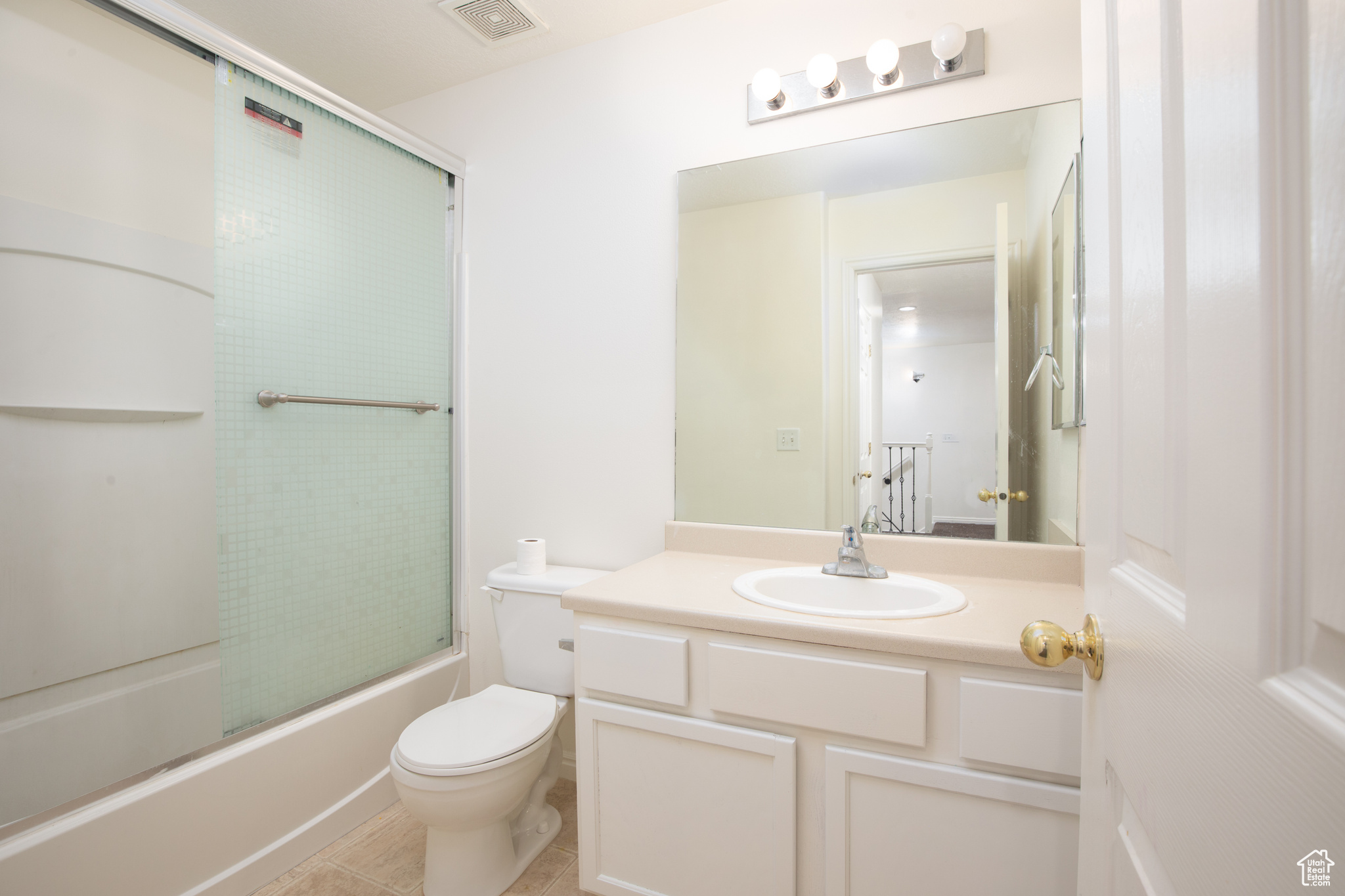 Full bathroom with tile flooring, vanity, toilet, and shower / bath combination with glass door