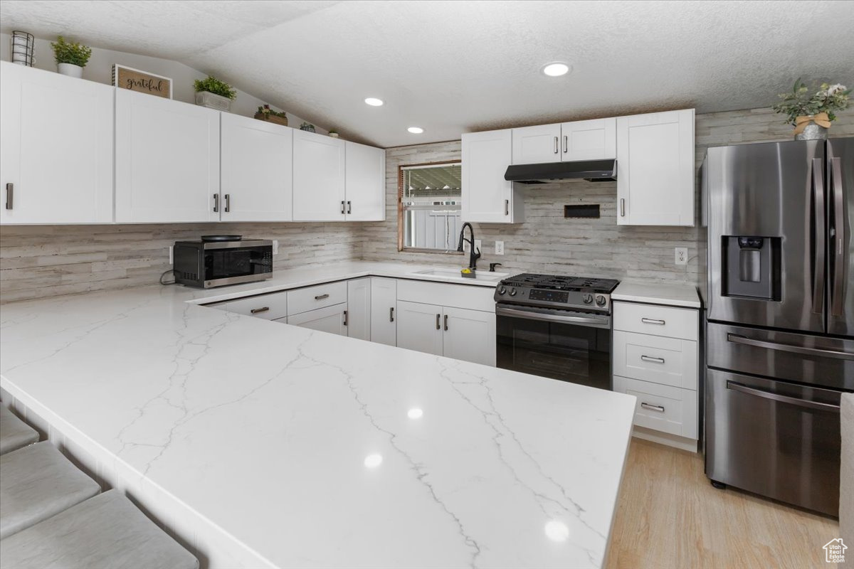 Kitchen featuring light hardwood / wood-style flooring, stainless steel appliances, white cabinets, and sink