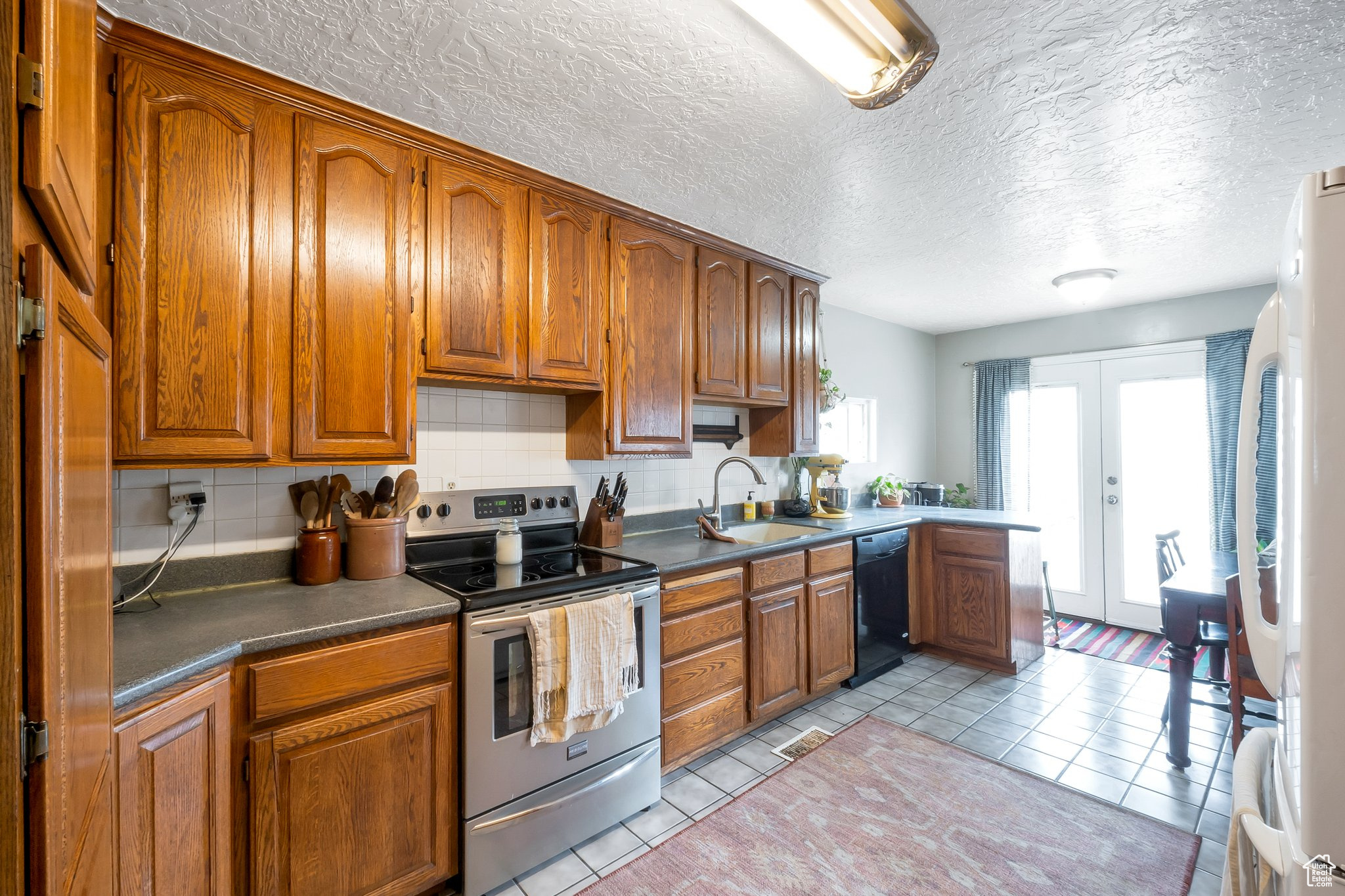 Lots of storage in this kitchen with oak cabinets and neutral tile. Range, dishwasher and refrigerator included.