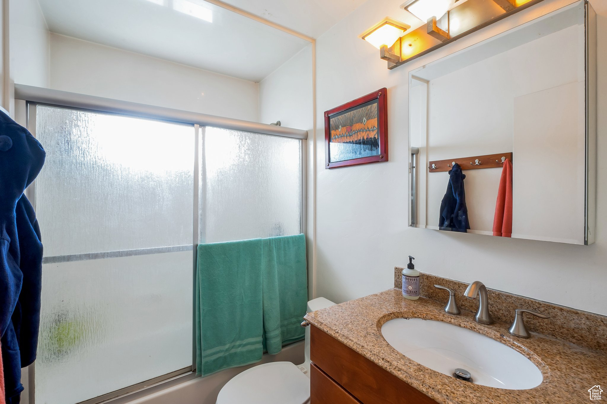 Main floor full bath/shower combo with glass sliding doors.