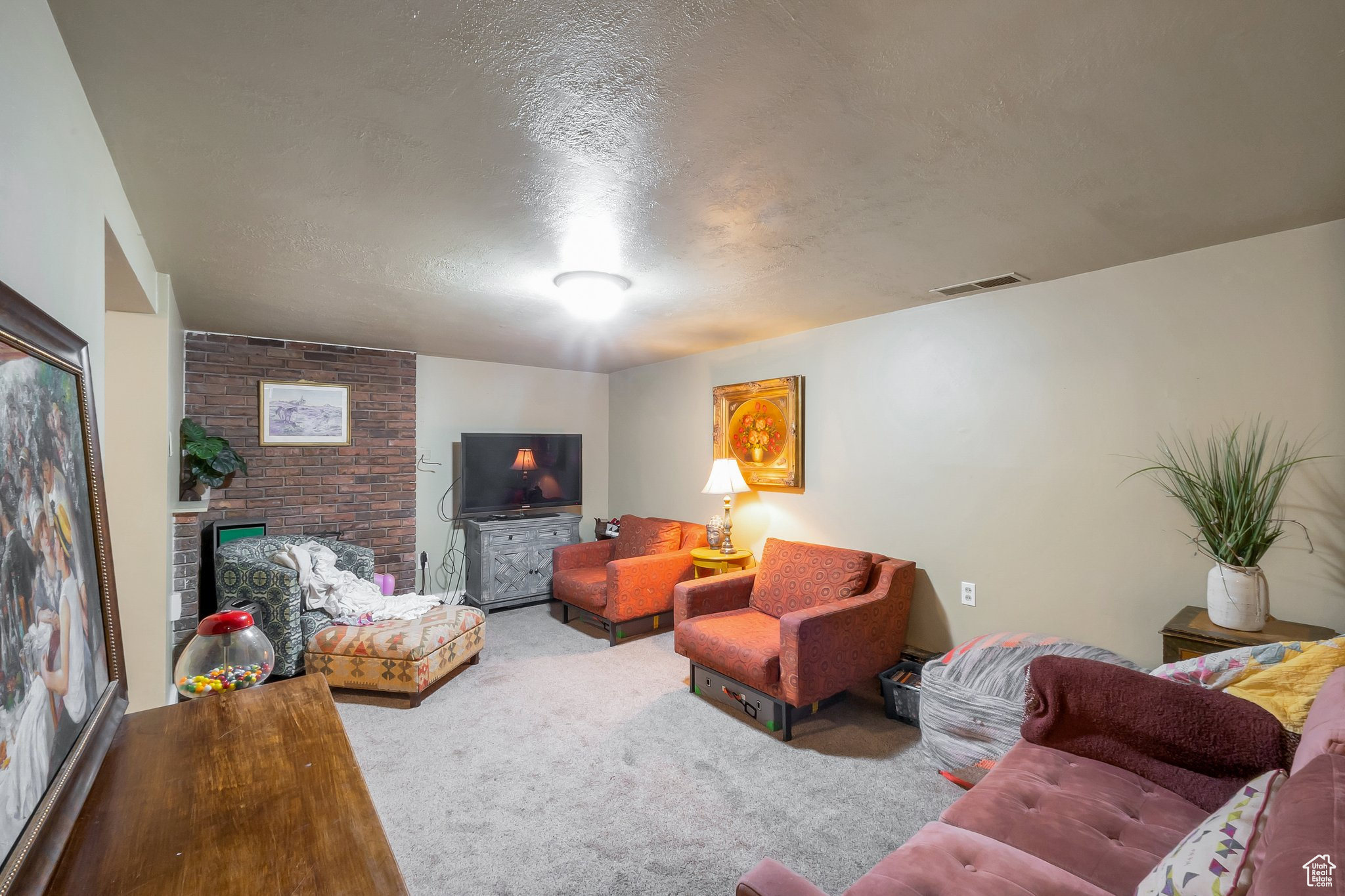 Basement family room with carpet and brick fireplace