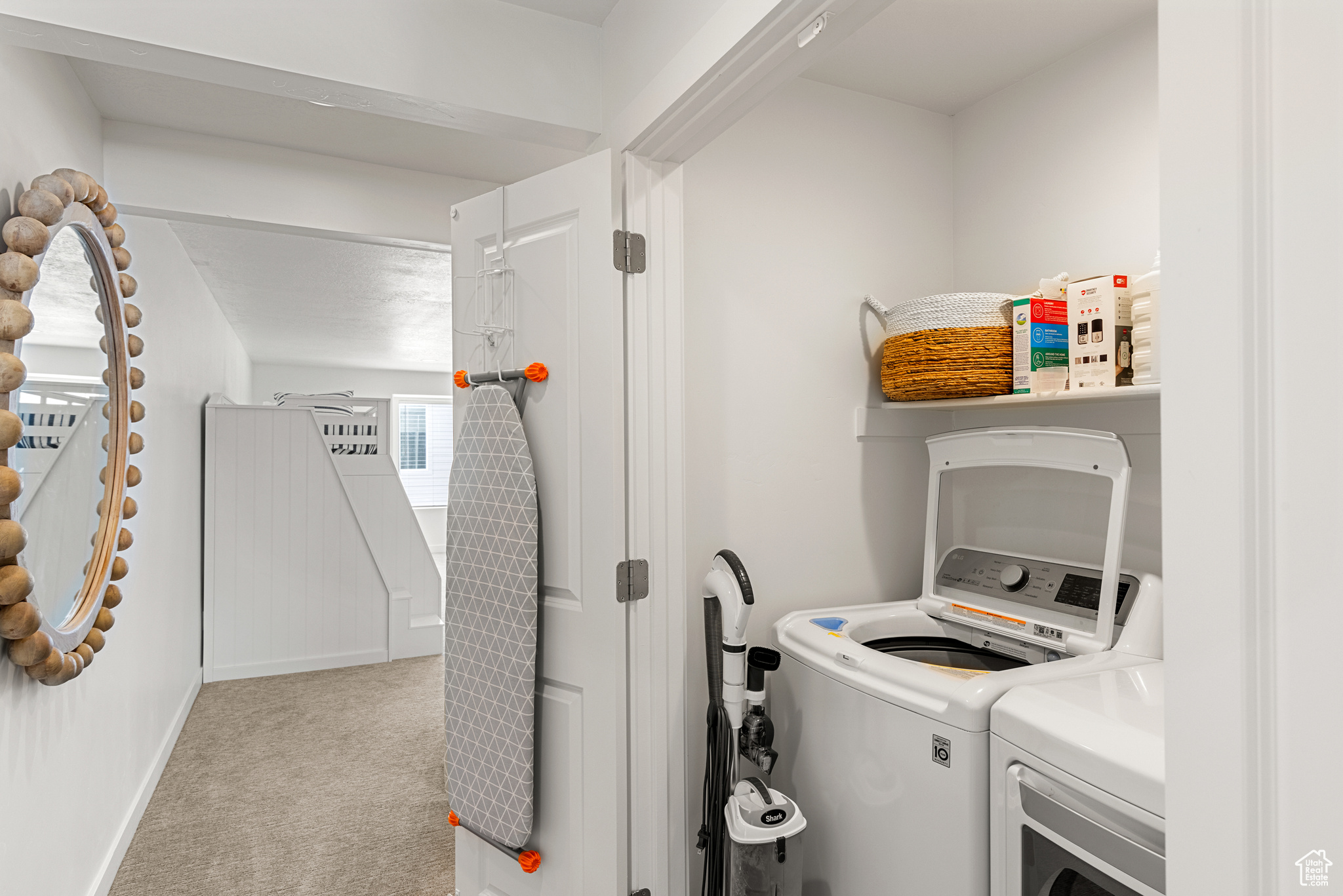 Laundry room with washing machine and clothes dryer and light carpet