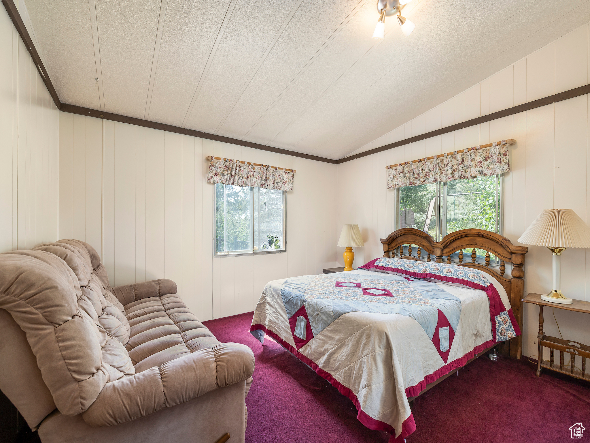 Bedroom featuring carpet flooring and lofted ceiling