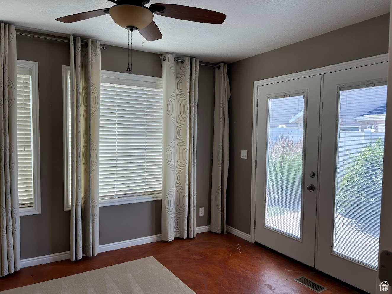 Doorway to outside with french doors, plenty of natural light, and ceiling fan