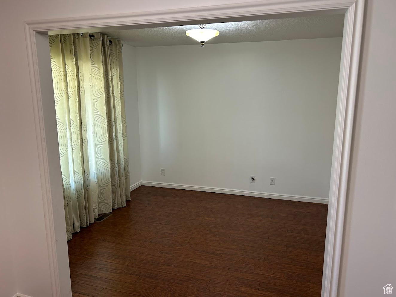 Empty room featuring dark hardwood / wood-style flooring