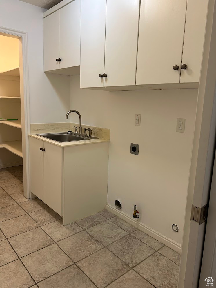 Laundry room with sink, hookup for a gas dryer, cabinets, light tile patterned floors, and electric dryer hookup