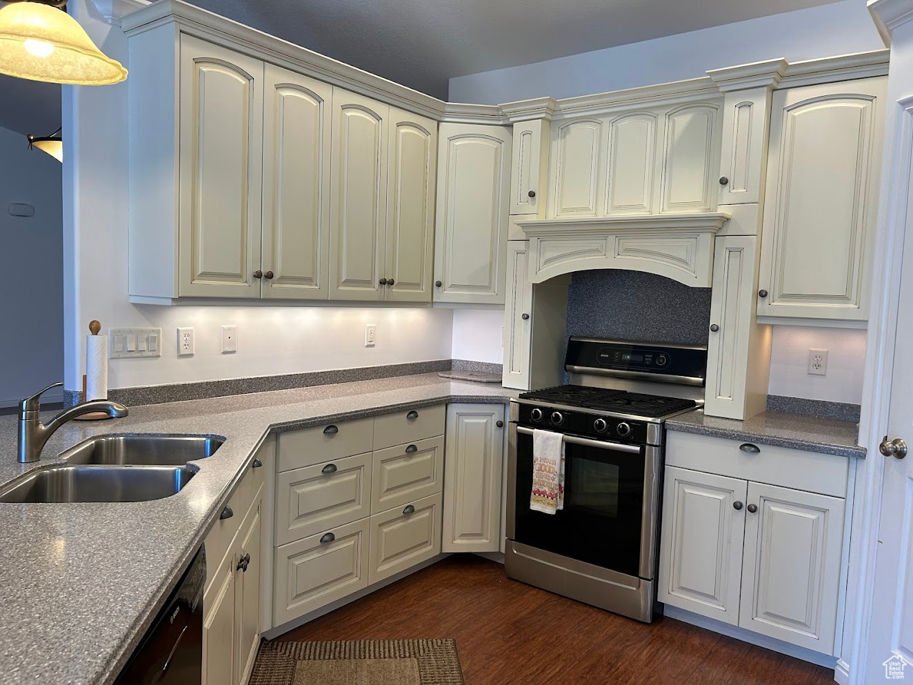 Kitchen featuring gas range, custom exhaust hood, sink, and dark wood-type flooring