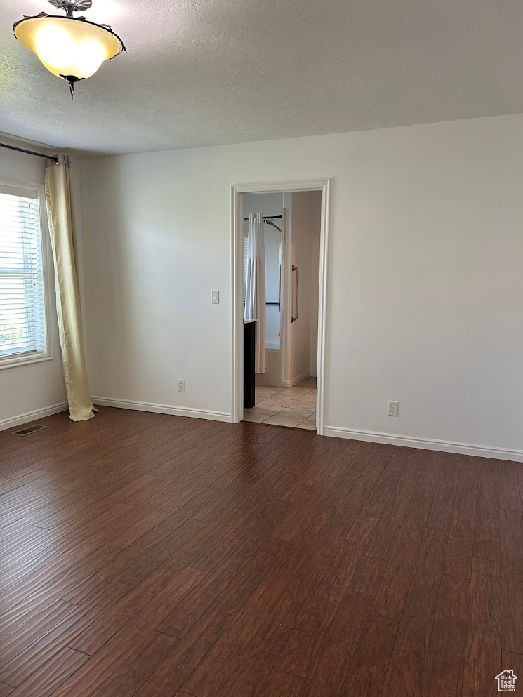 Master bedroom featuring a textured ceiling and hardwood / wood-style flooring