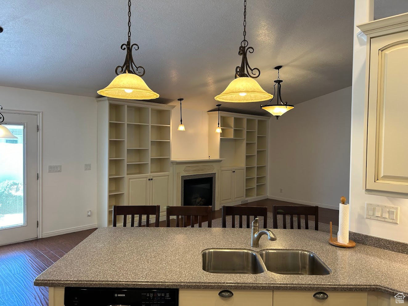 Kitchen with sink, pendant lighting, dark hardwood / wood-style floors, a textured ceiling, and dishwasher