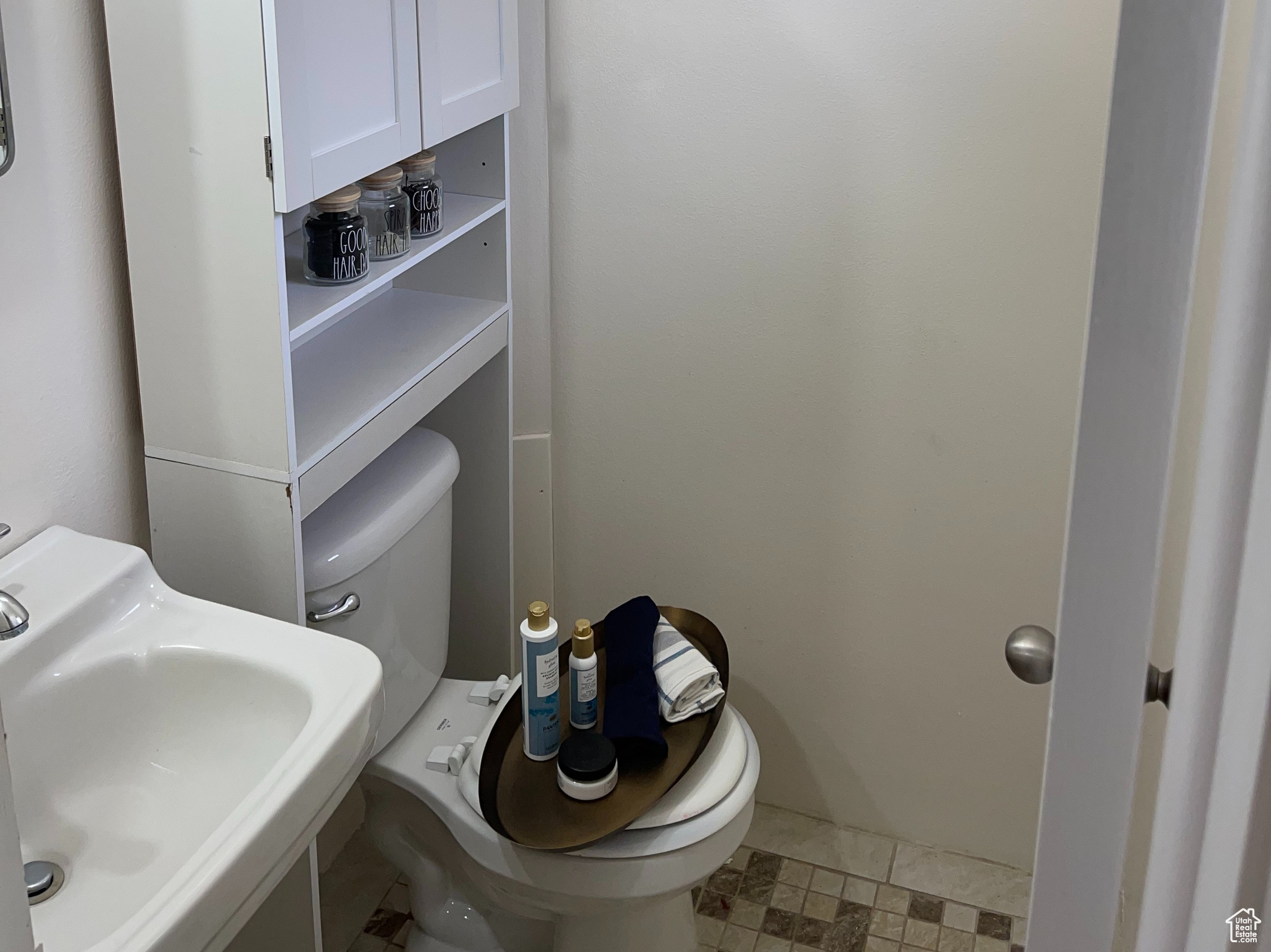Half Bathroom with sink, toilet, and tile flooring