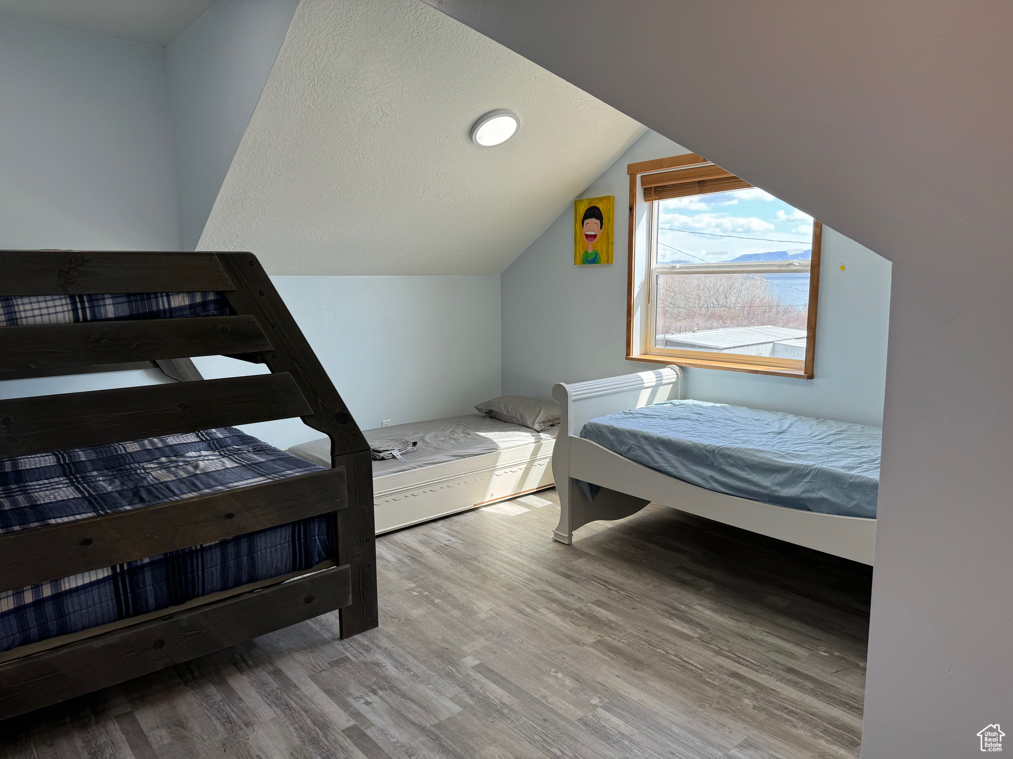 Bedroom featuring LVP flooring and lofted ceiling