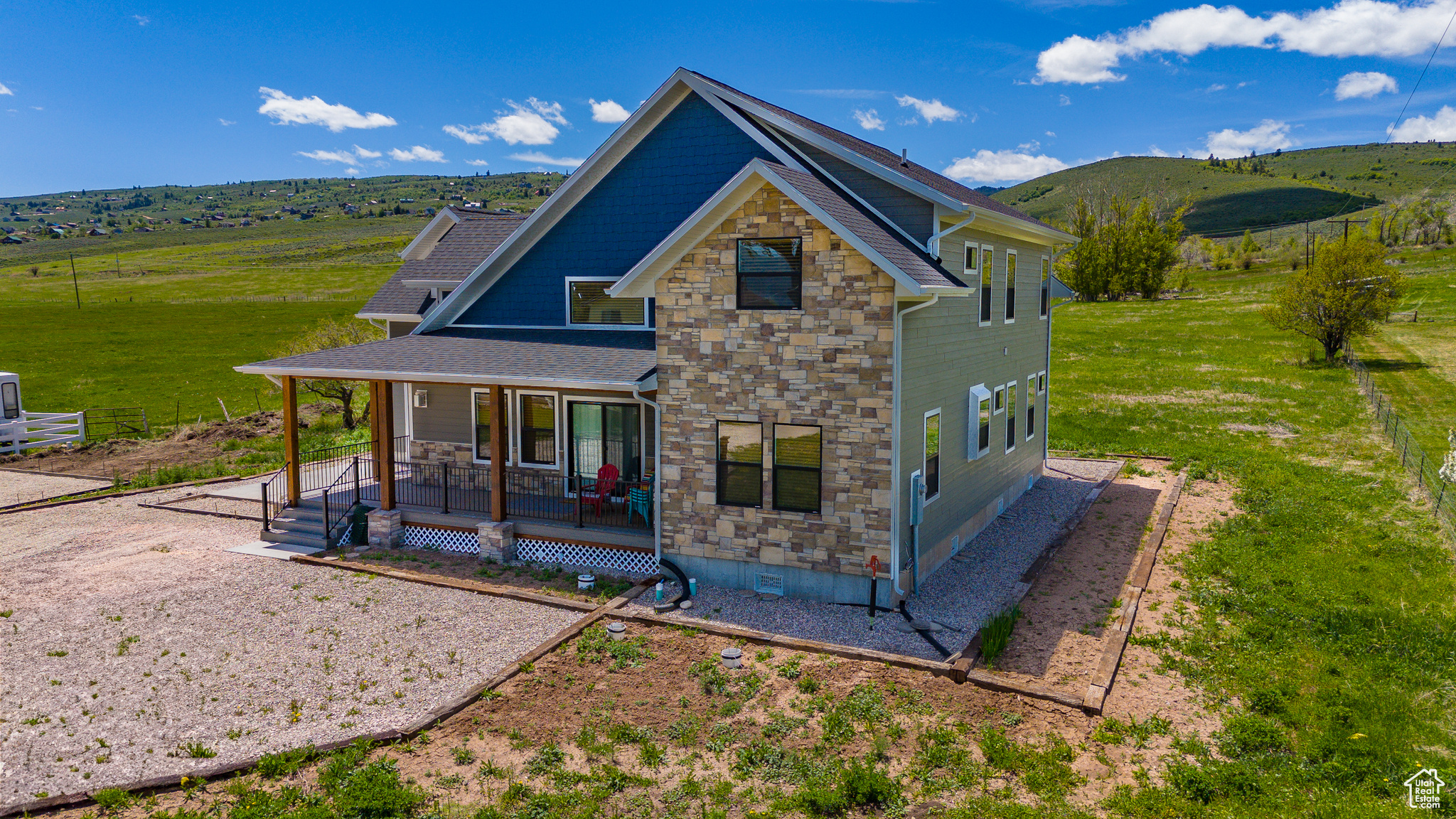 Back of property with covered porch and a rural view