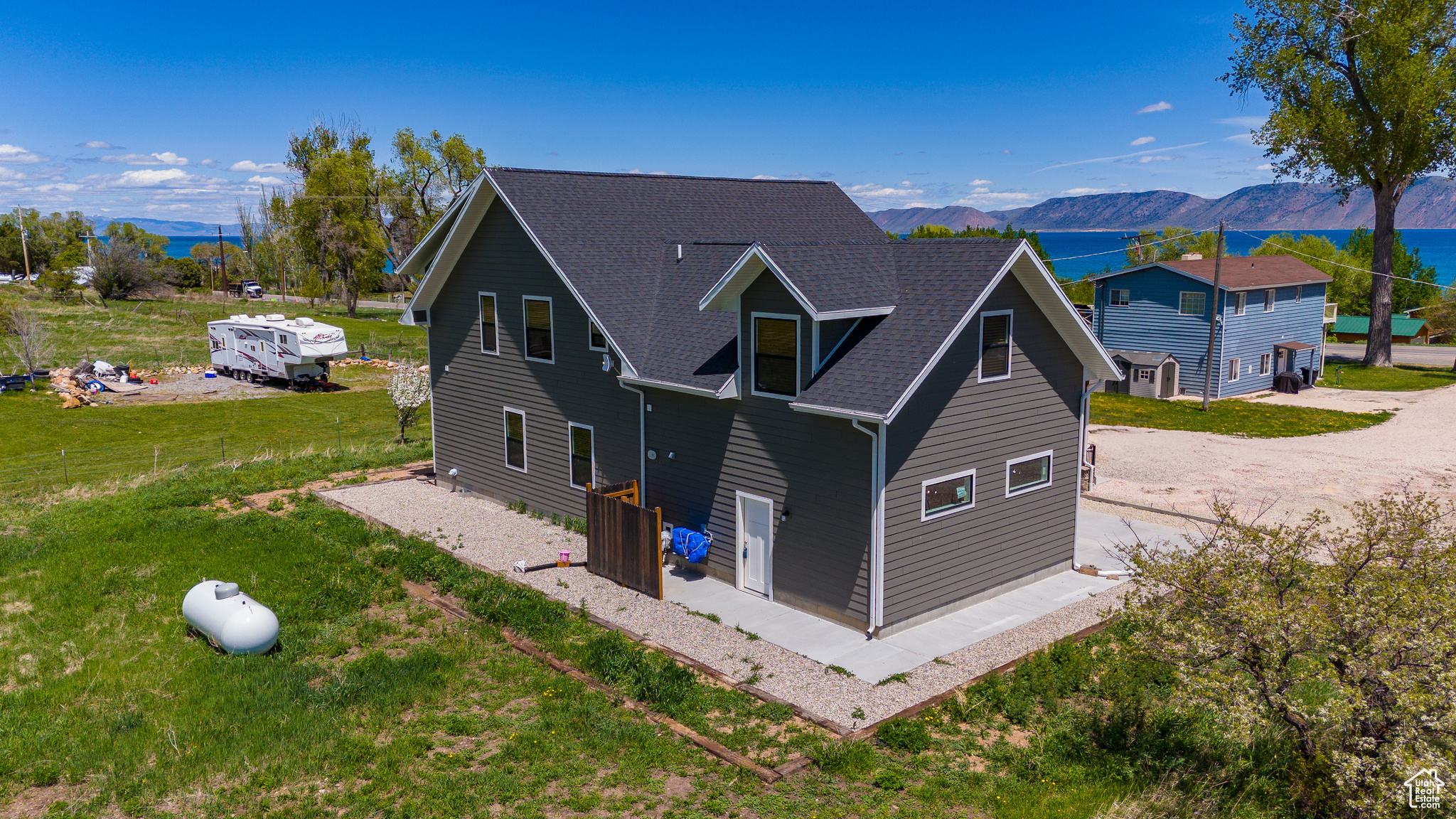 Back of house with a garage, a mountain view, and a yard