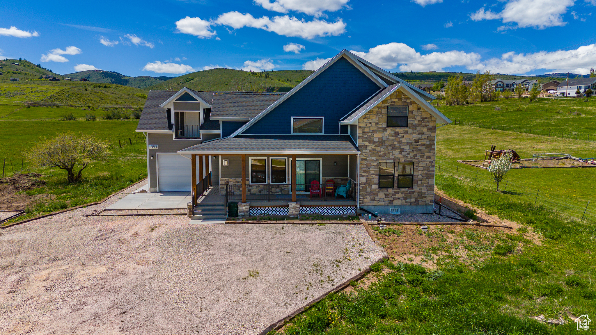 Exterior space with a garage, a mountain view, a front yard, and covered porch