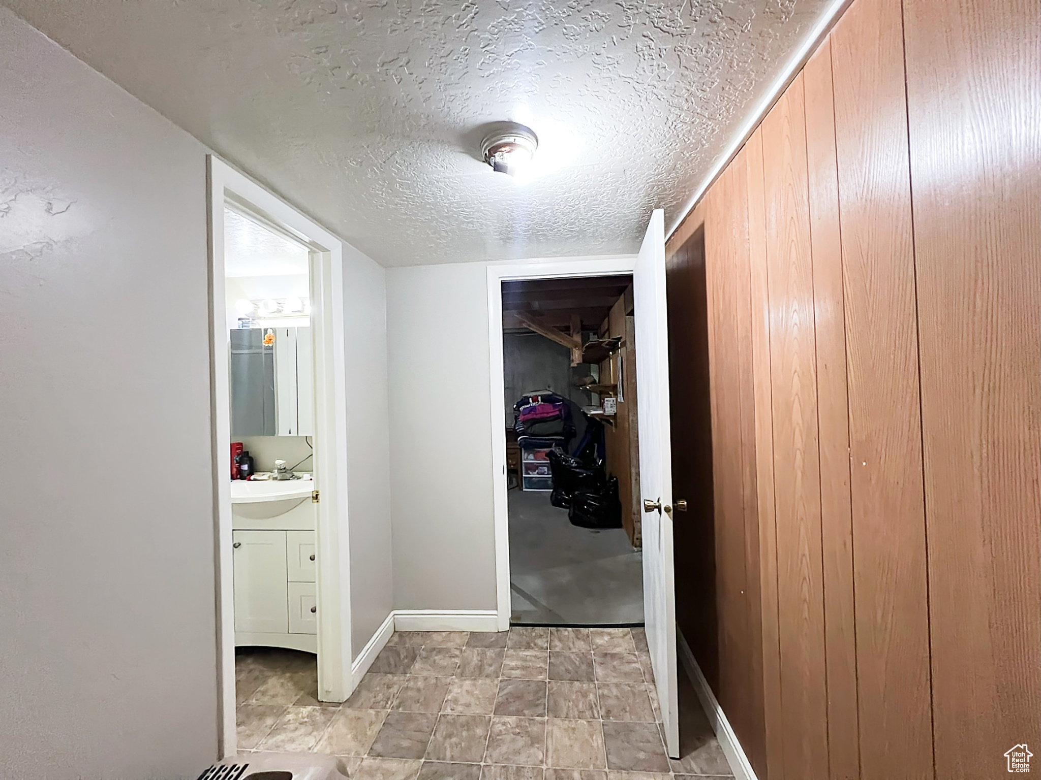 Hallway featuring a textured ceiling and sink