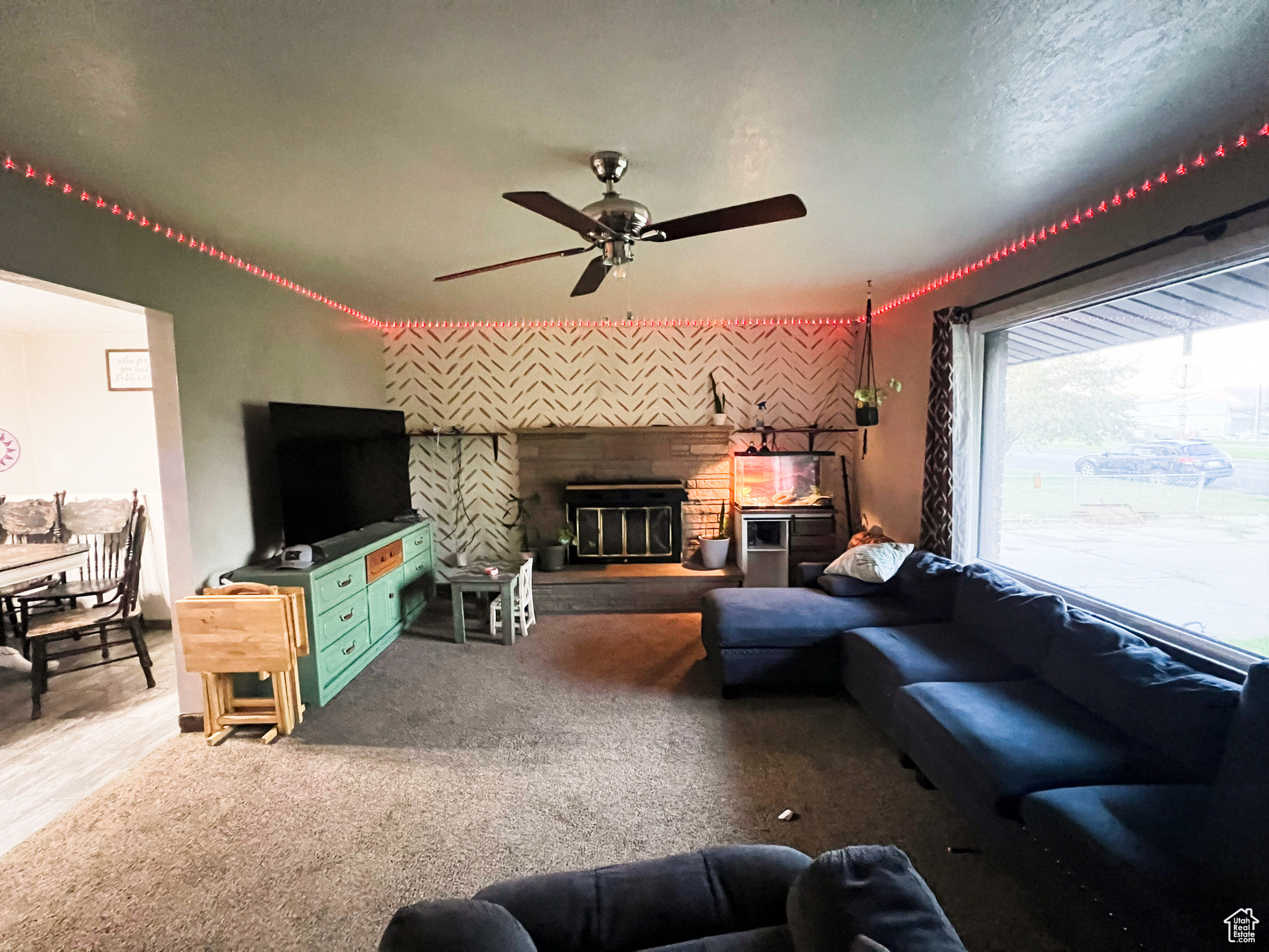 Living room featuring ceiling fan, carpet floors, and a textured ceiling