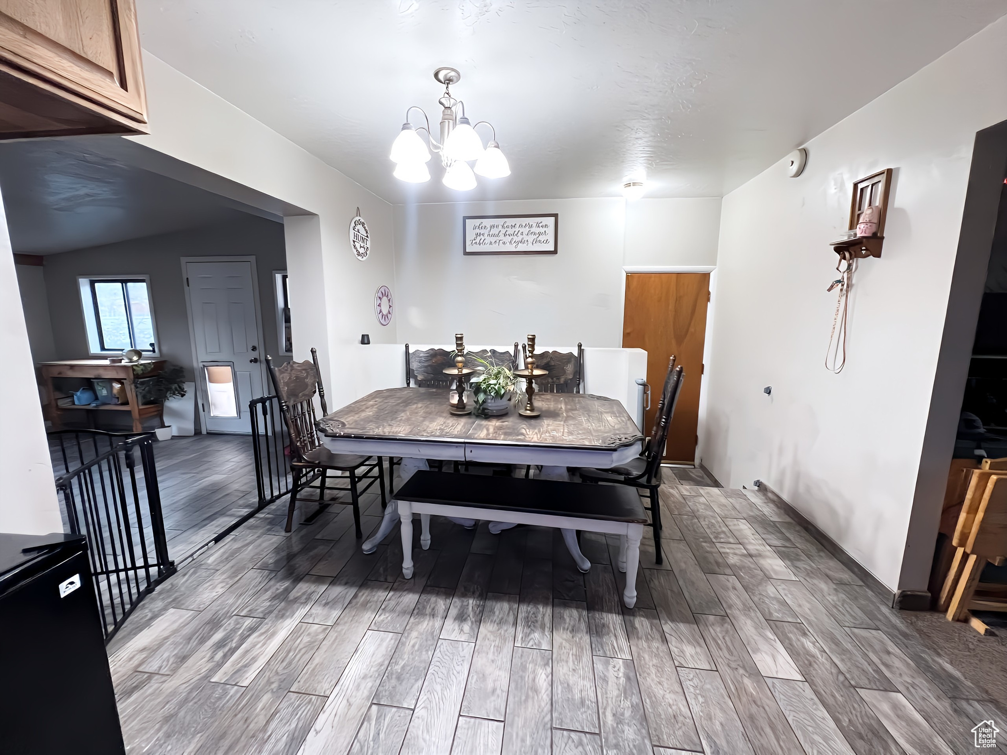 Dining space featuring vaulted ceiling, hardwood / wood-style flooring, and a notable chandelier