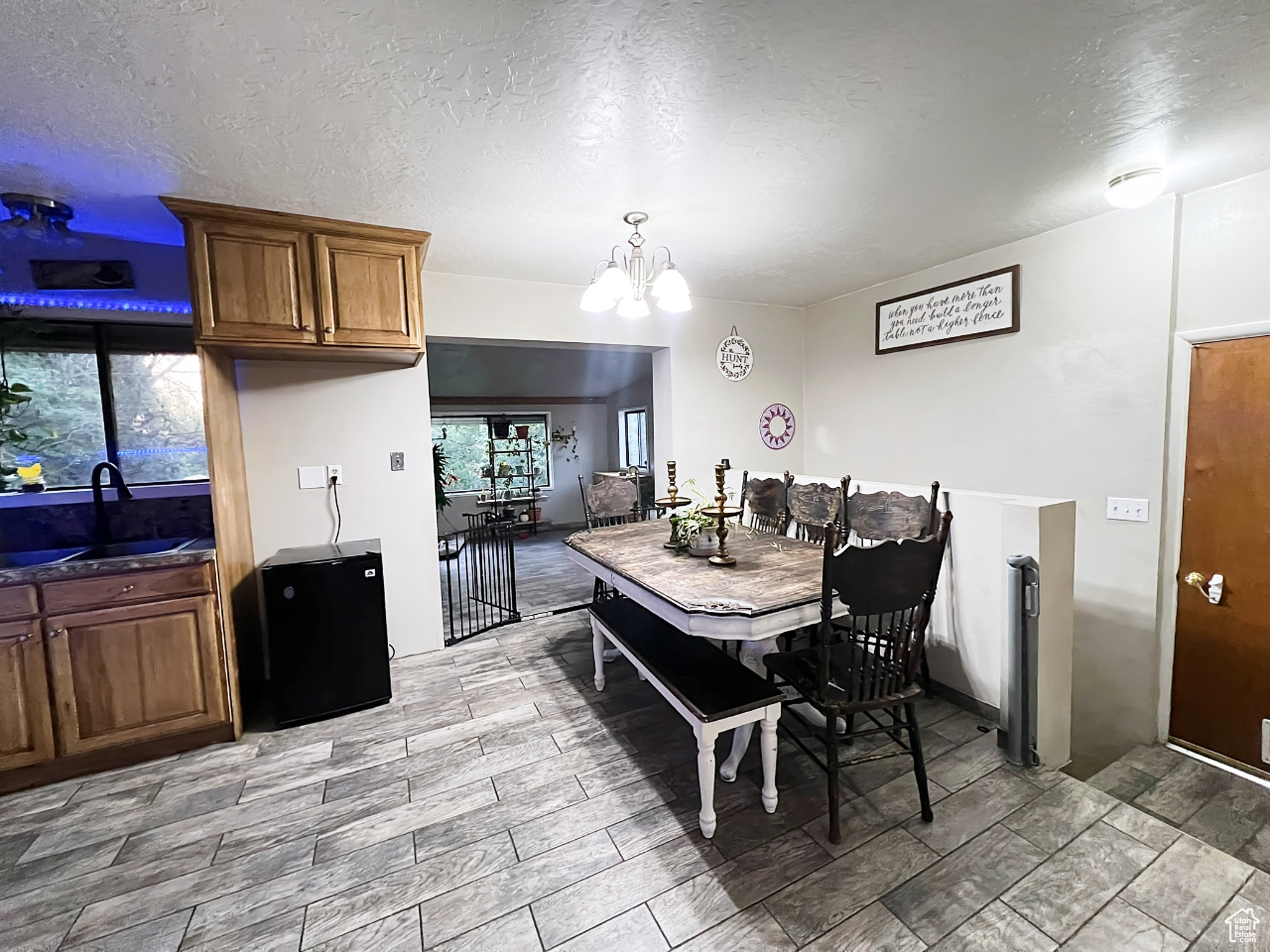 Dining area featuring a textured ceiling, sink, and a chandelier