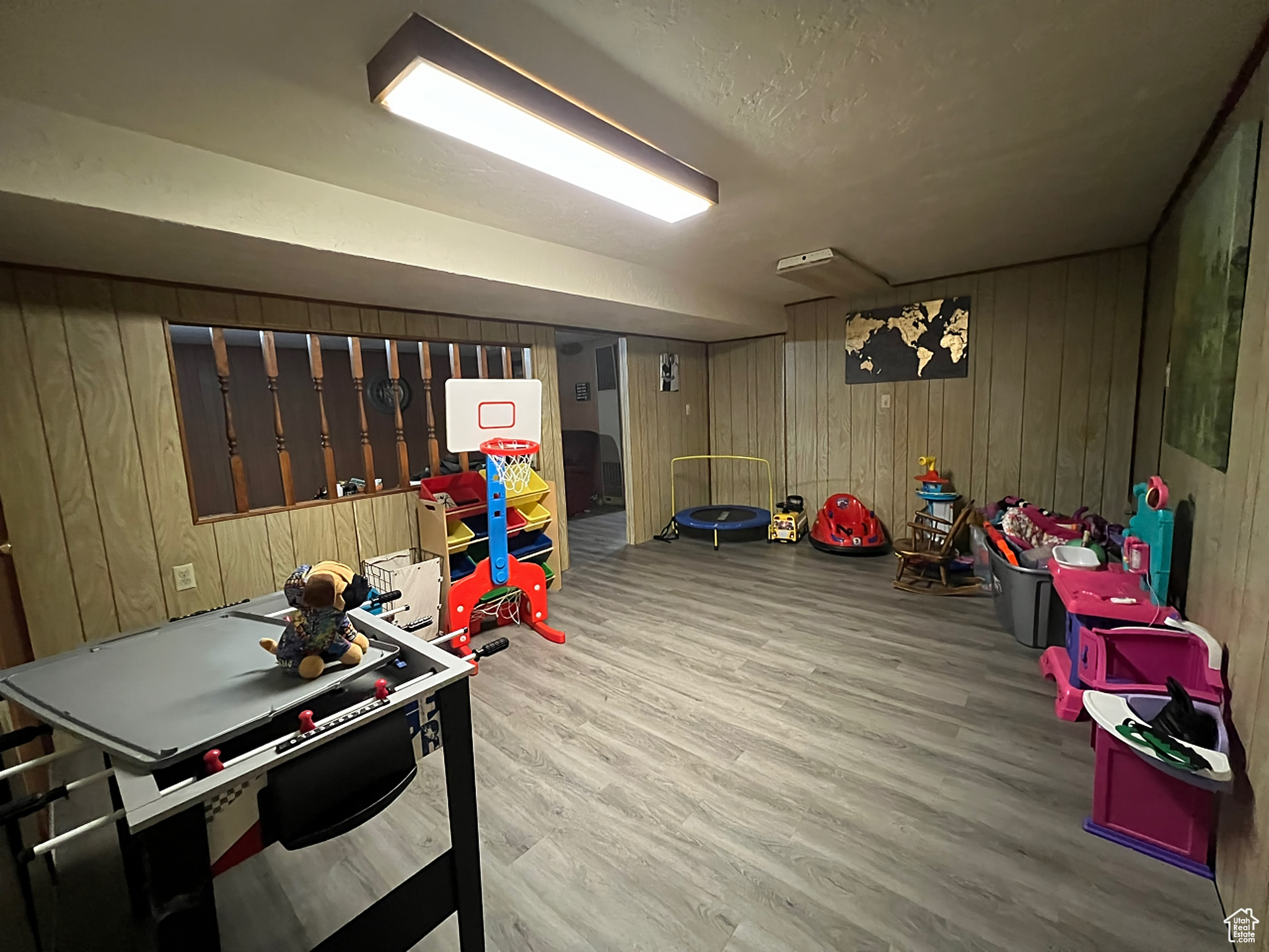 Rec room with wood walls and hardwood / wood-style flooring