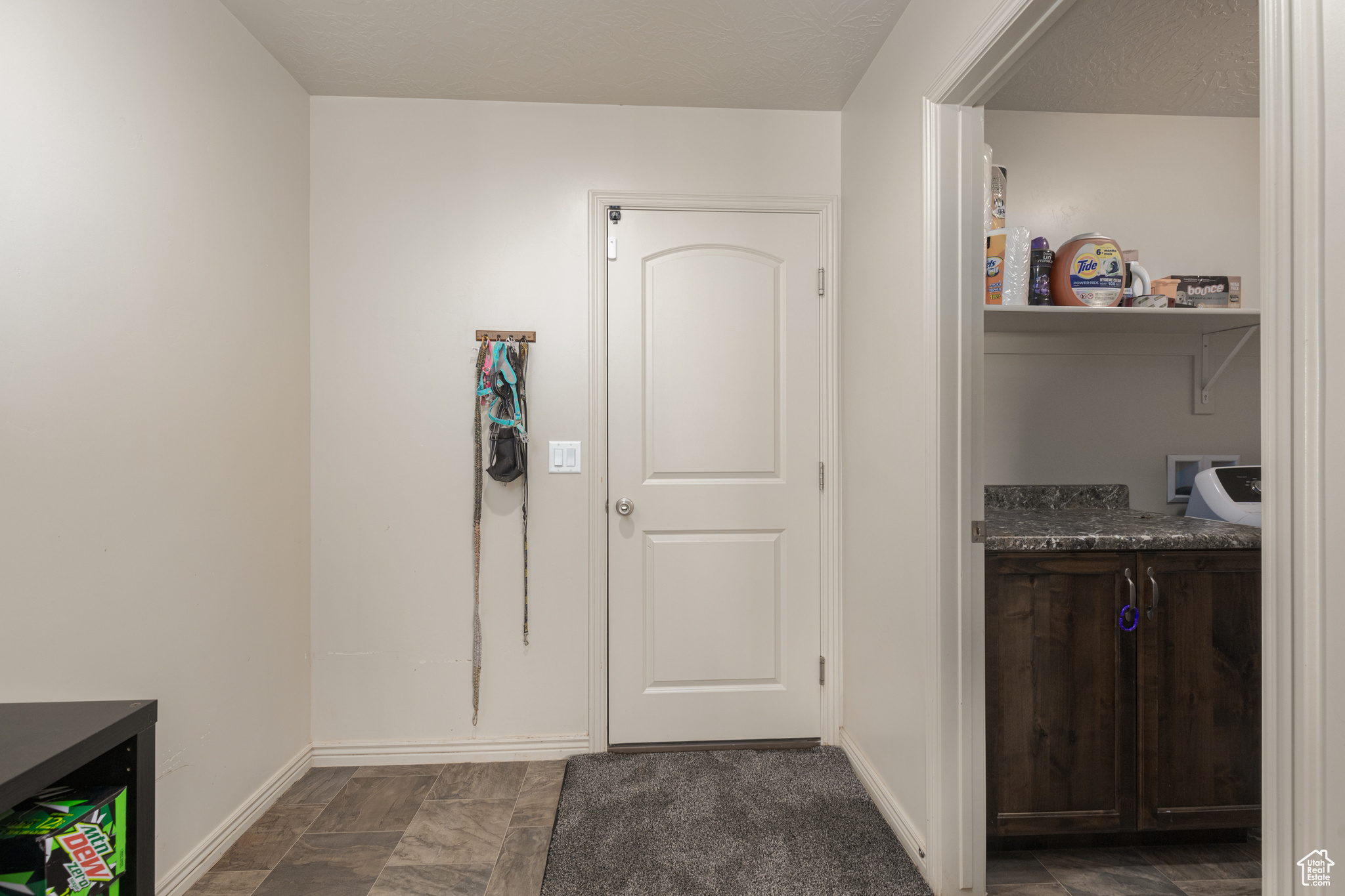 Laundry room with dark tile floors