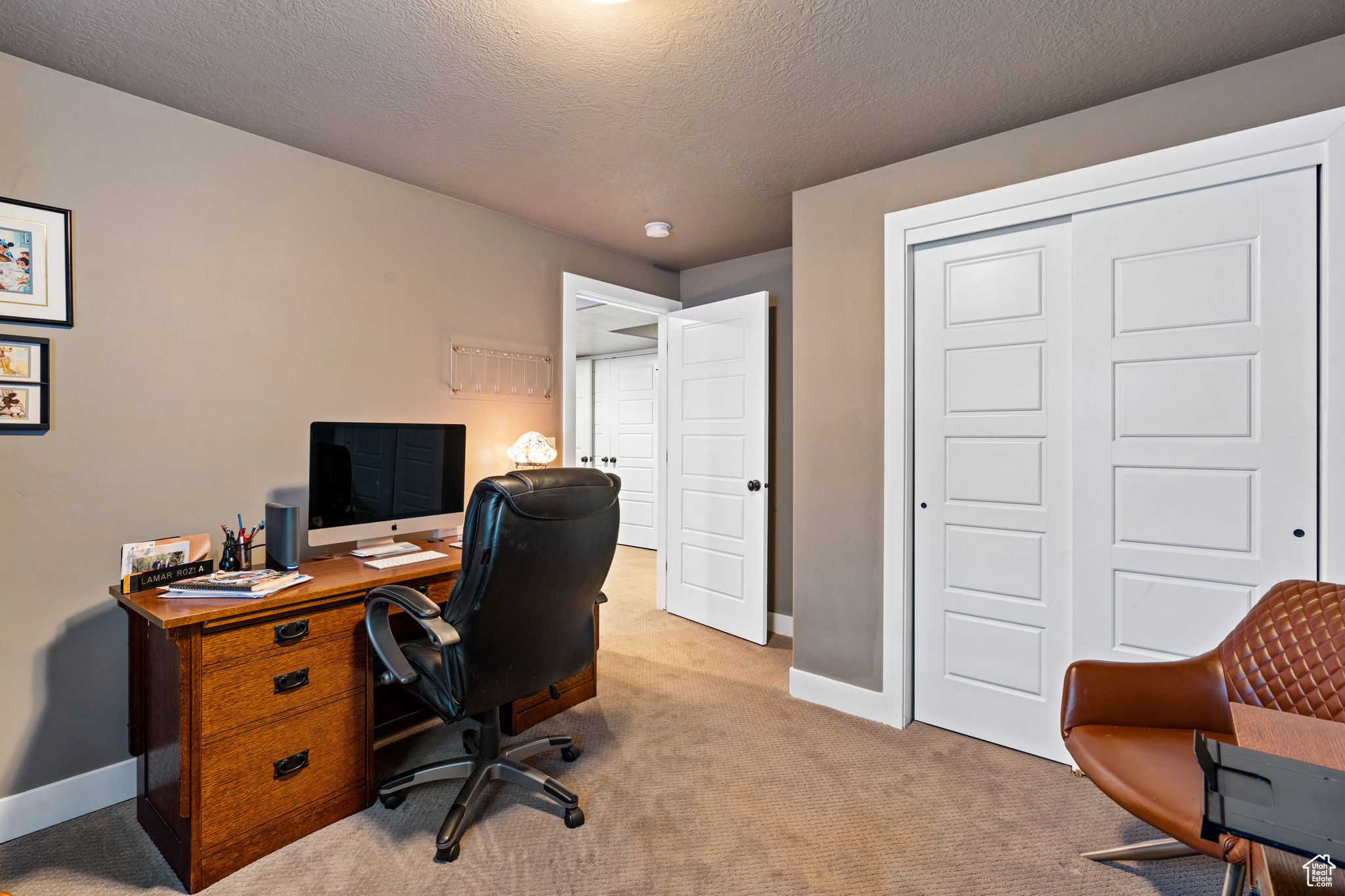 Office space featuring light colored carpet and a textured ceiling