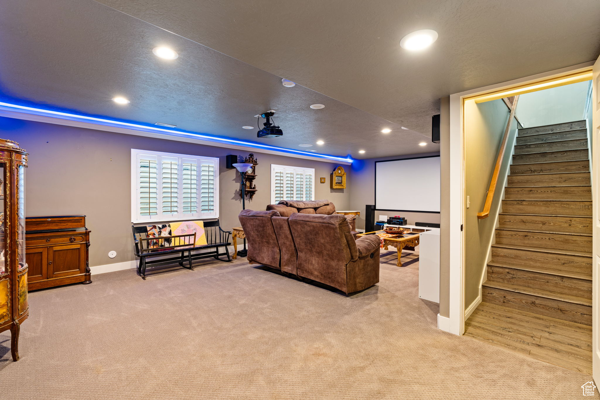 living room in basement with theater lighting and stairs