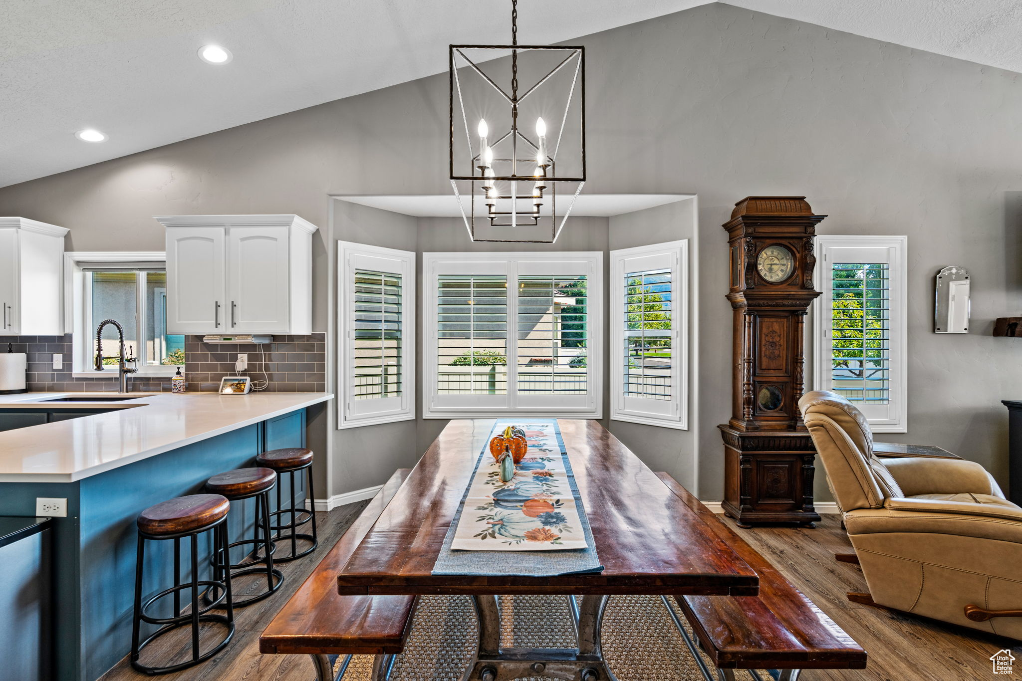 Dining space featuring hardwood / wood-style floors, sink, and high vaulted ceiling