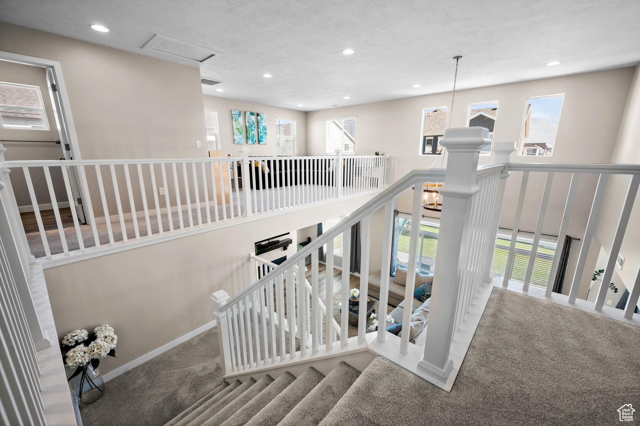 Stairs featuring plenty of natural light and carpet