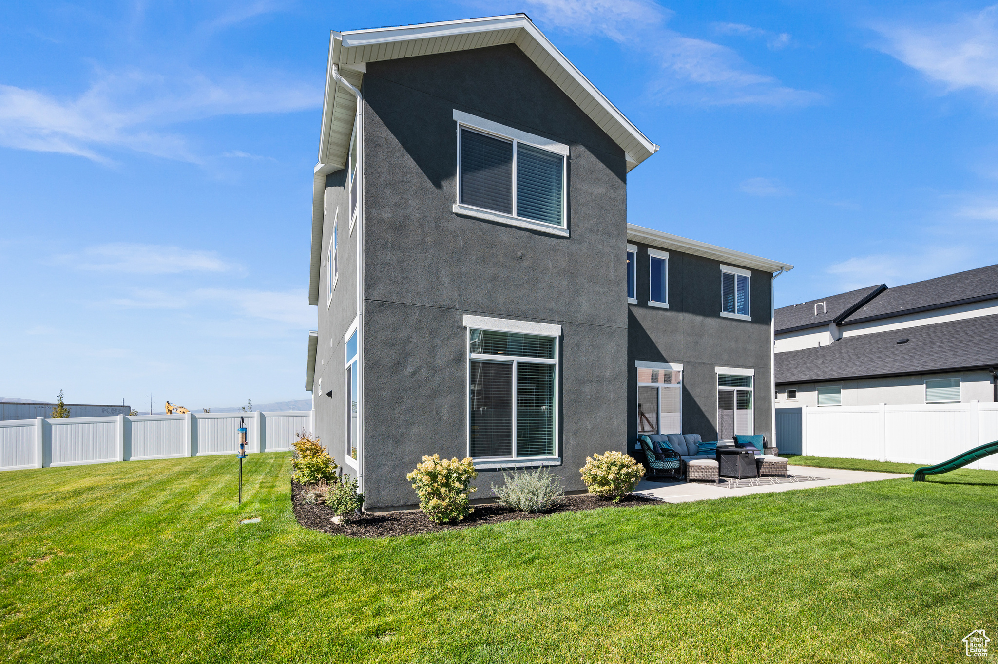 Rear view of house featuring an outdoor living space, a patio area, and a lawn