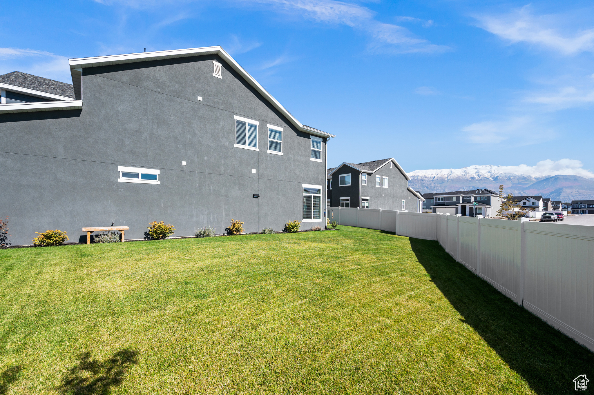 Rear view of house featuring a mountain view and a lawn