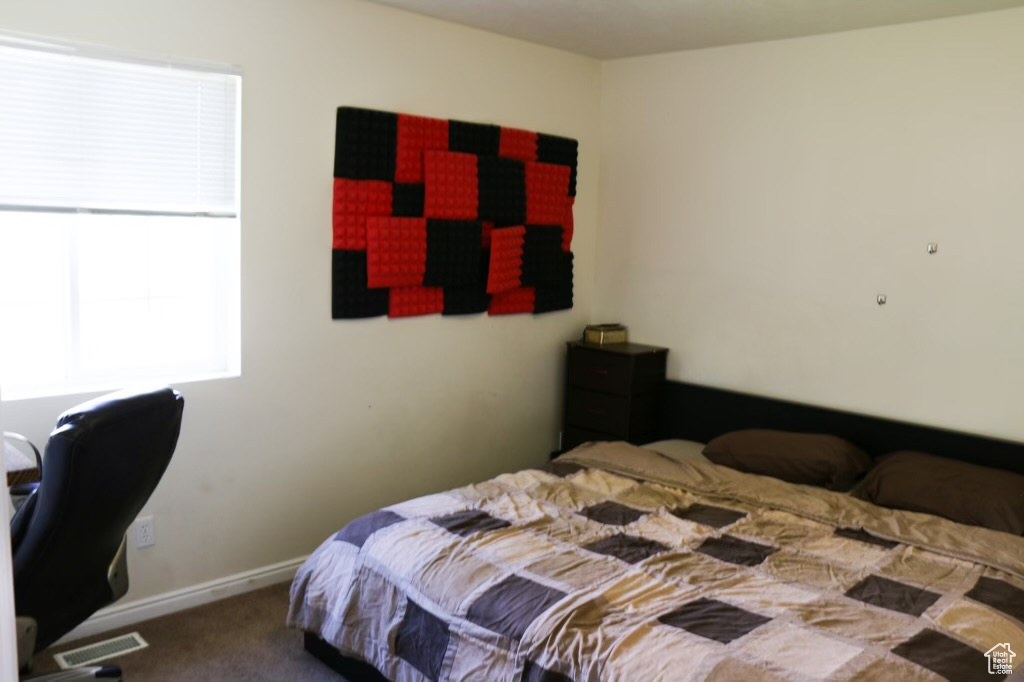 Bedroom featuring dark colored carpet