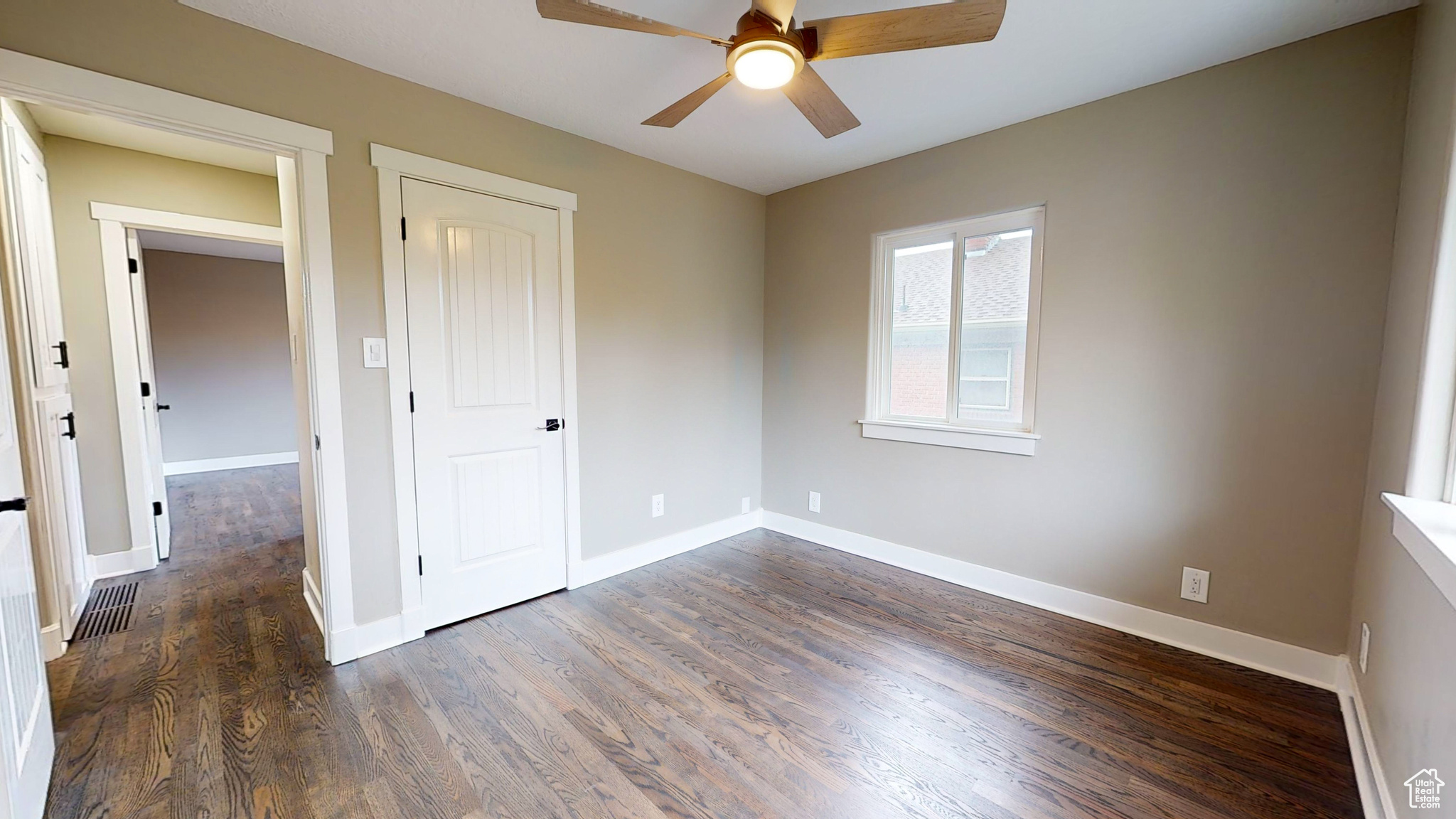 Spare room with ceiling fan and dark wood-type flooring