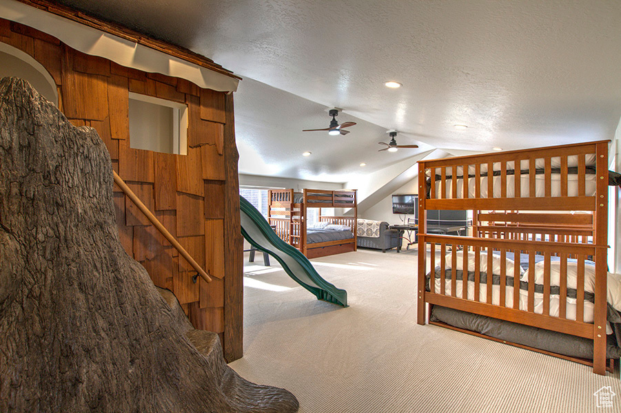 Bunk room loft  with TV, foose ball table and playhouse with slide.