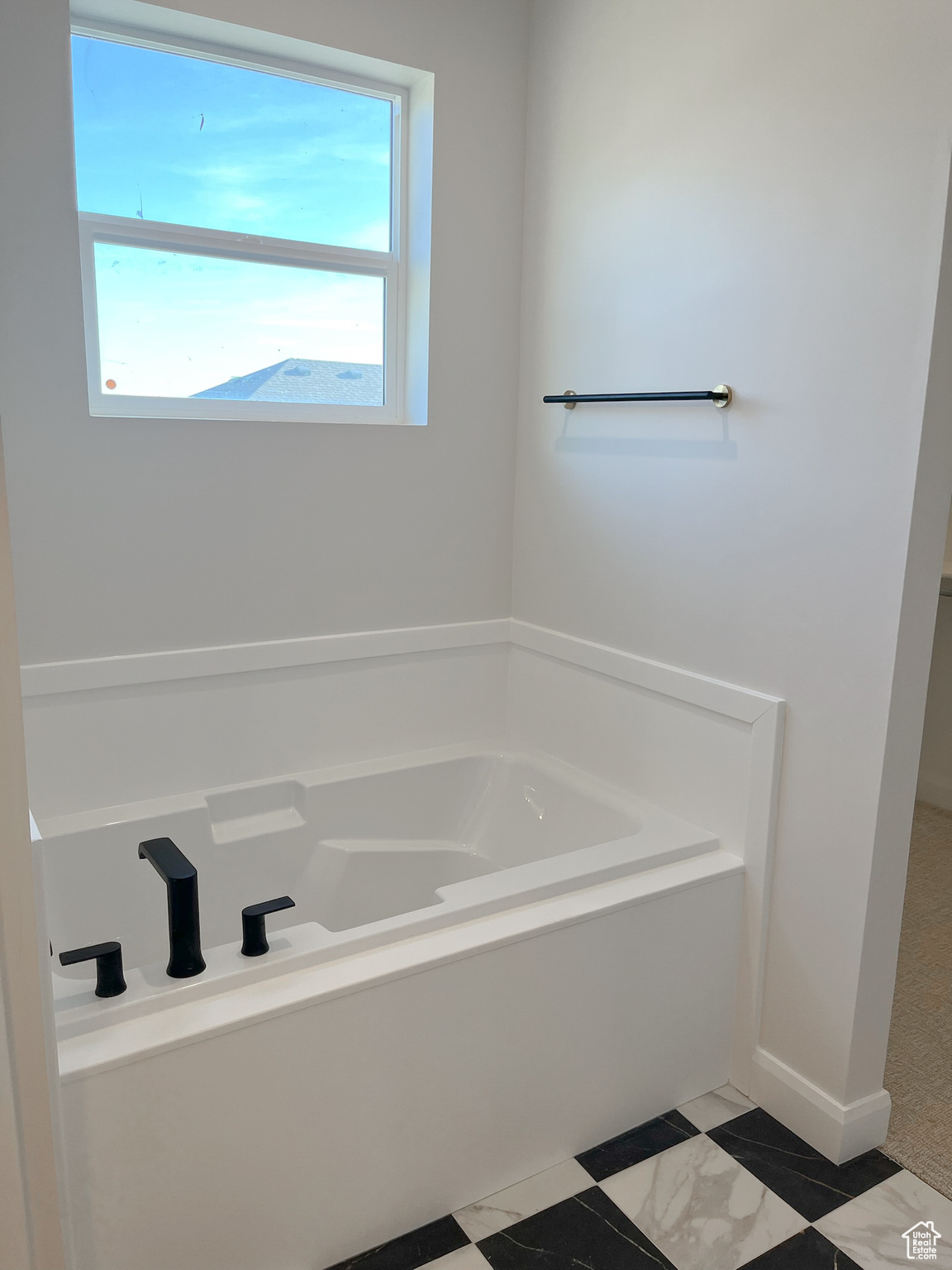 Bathroom featuring plenty of natural light, a bath to relax in, and tile flooring