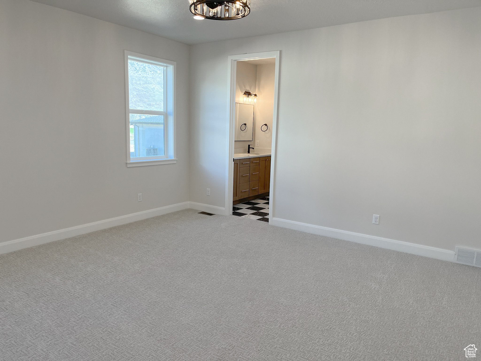 Interior space with ensuite bath and light carpet